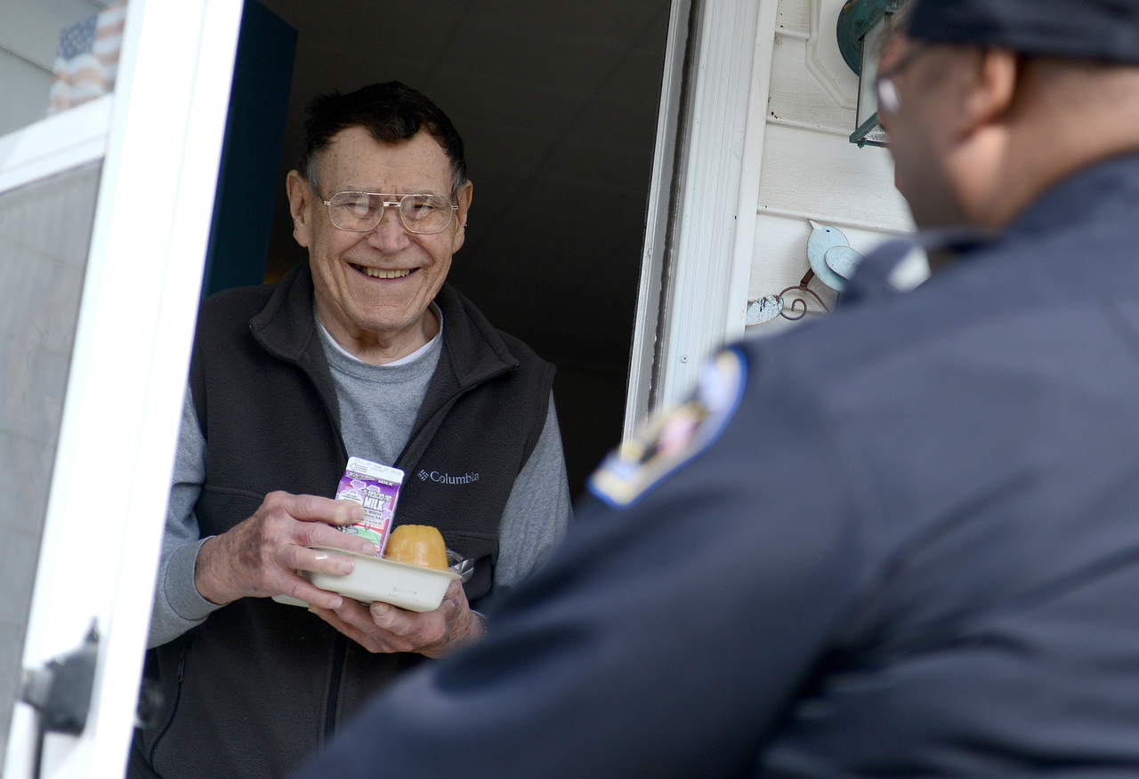  Sandusky resident Ben Widman smiles as Meals on Wheels volunteer Dan McLaughlin and officer Chris Rankins delivers food during the program's March For Meals celebrity ride-alongs on Monday, March 12, 2018. 