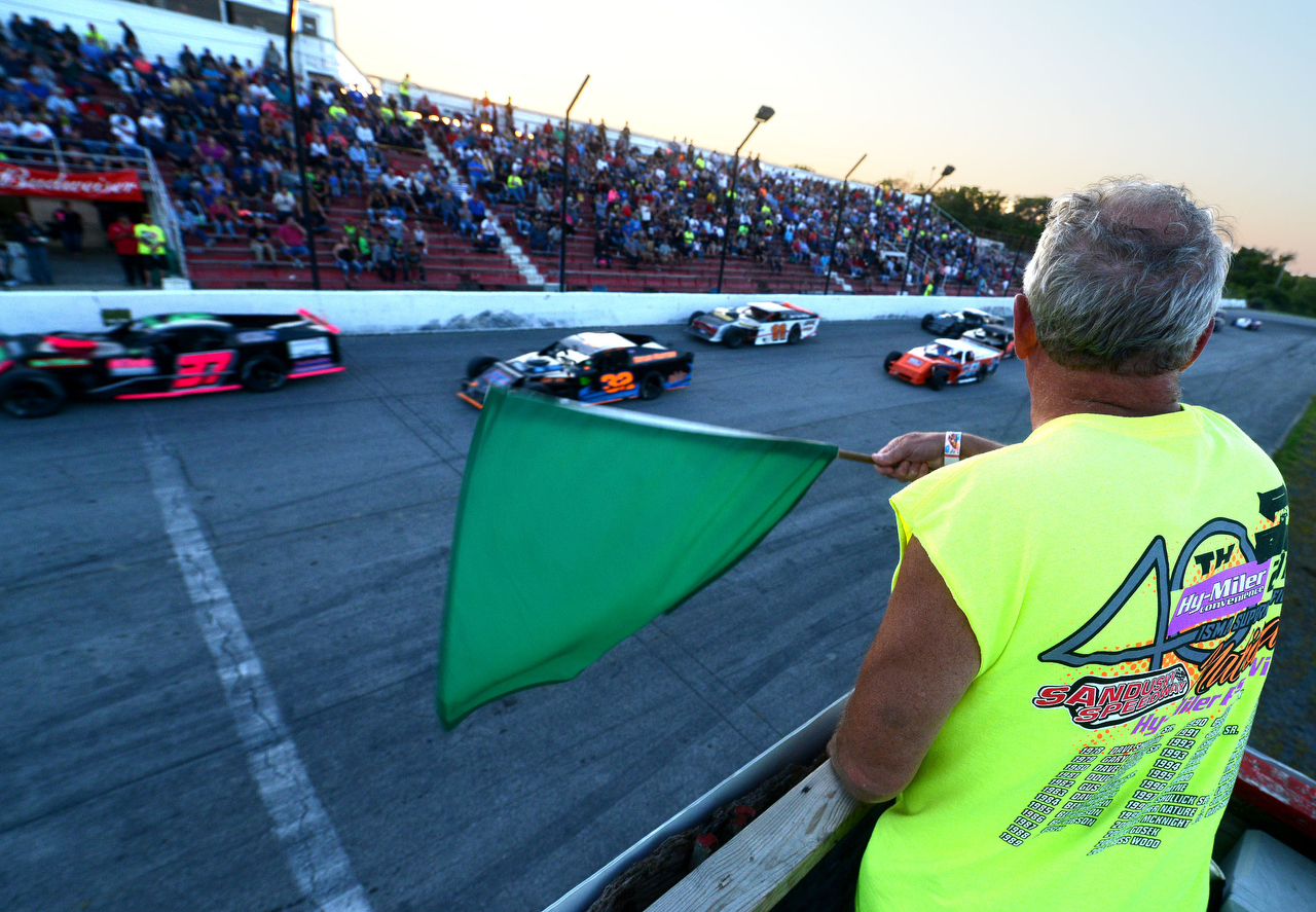  Dennis Capek, of Rocky River, waves the green flag to start the modified 35-lap feature race at Sandusky Speedway's Hy-Miler Nationals on Saturday. Capek was chosen to be the race marshal after regularly attending events at the speedway. "It felt gr