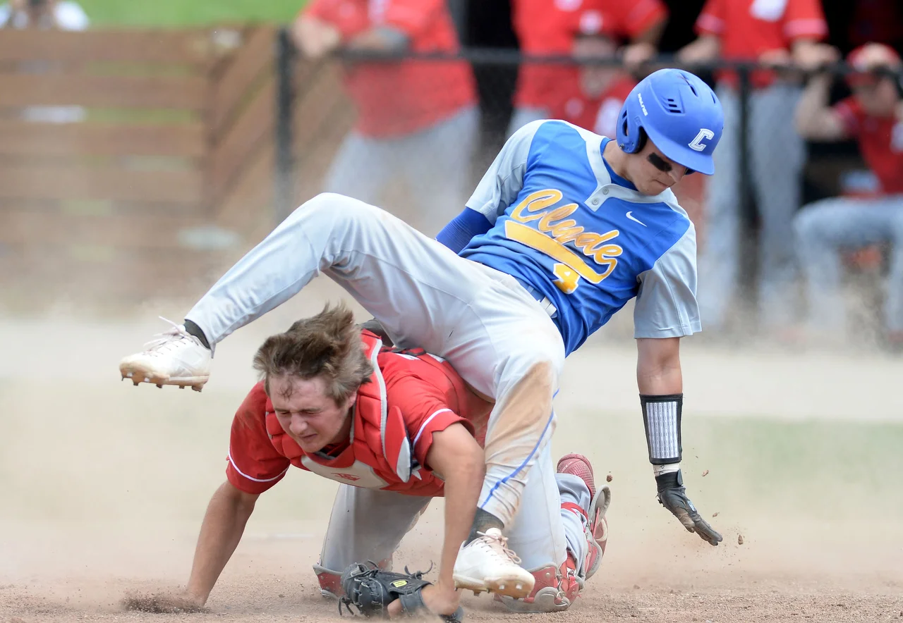  Clyde's Parker Reese trips over Bellevue's catcher Ben Smith to make a run at Heidelberg University's Peaceful Valley Complex in Tiffin during the Division II district semifinal on Thursday, May 18, 2017. The last inning of the game was a wild ride 