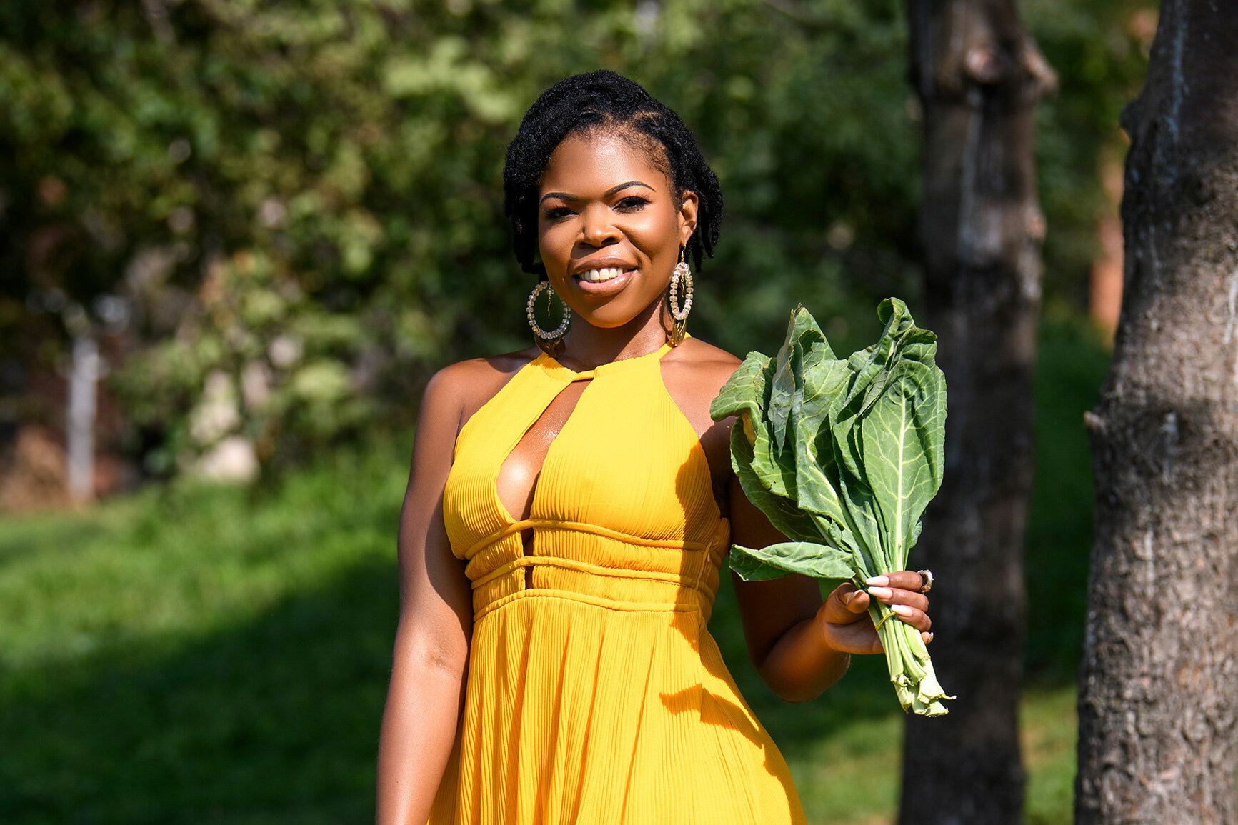  Alicia Hudson, smiling with a freshly picked bushel of collard greens 