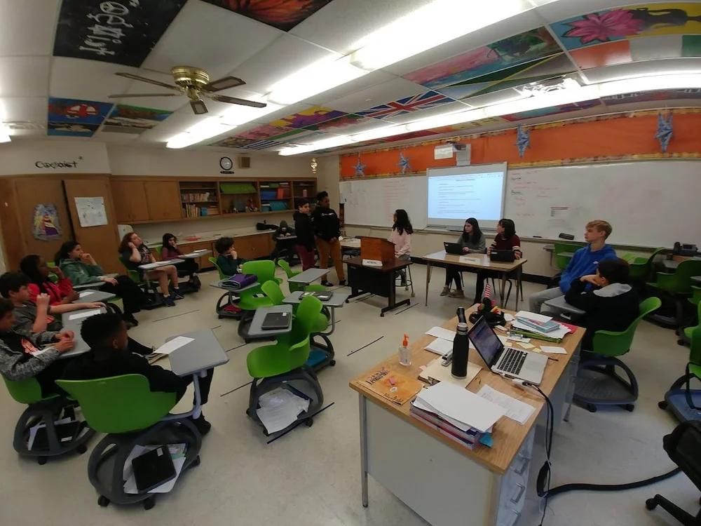 A social studies classroom at Shaker Heights High School with students working at tables and a projected lesson