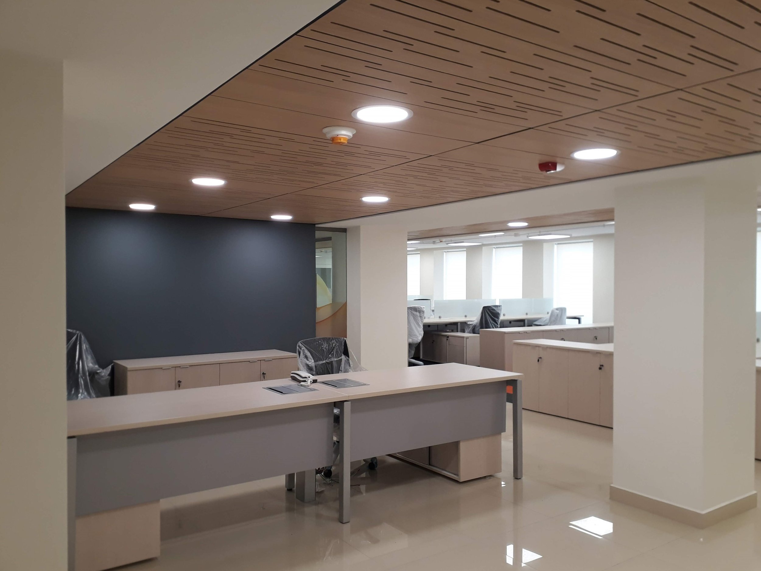 oficina moderna vacía con escritorios, sillas y ventanas grandes