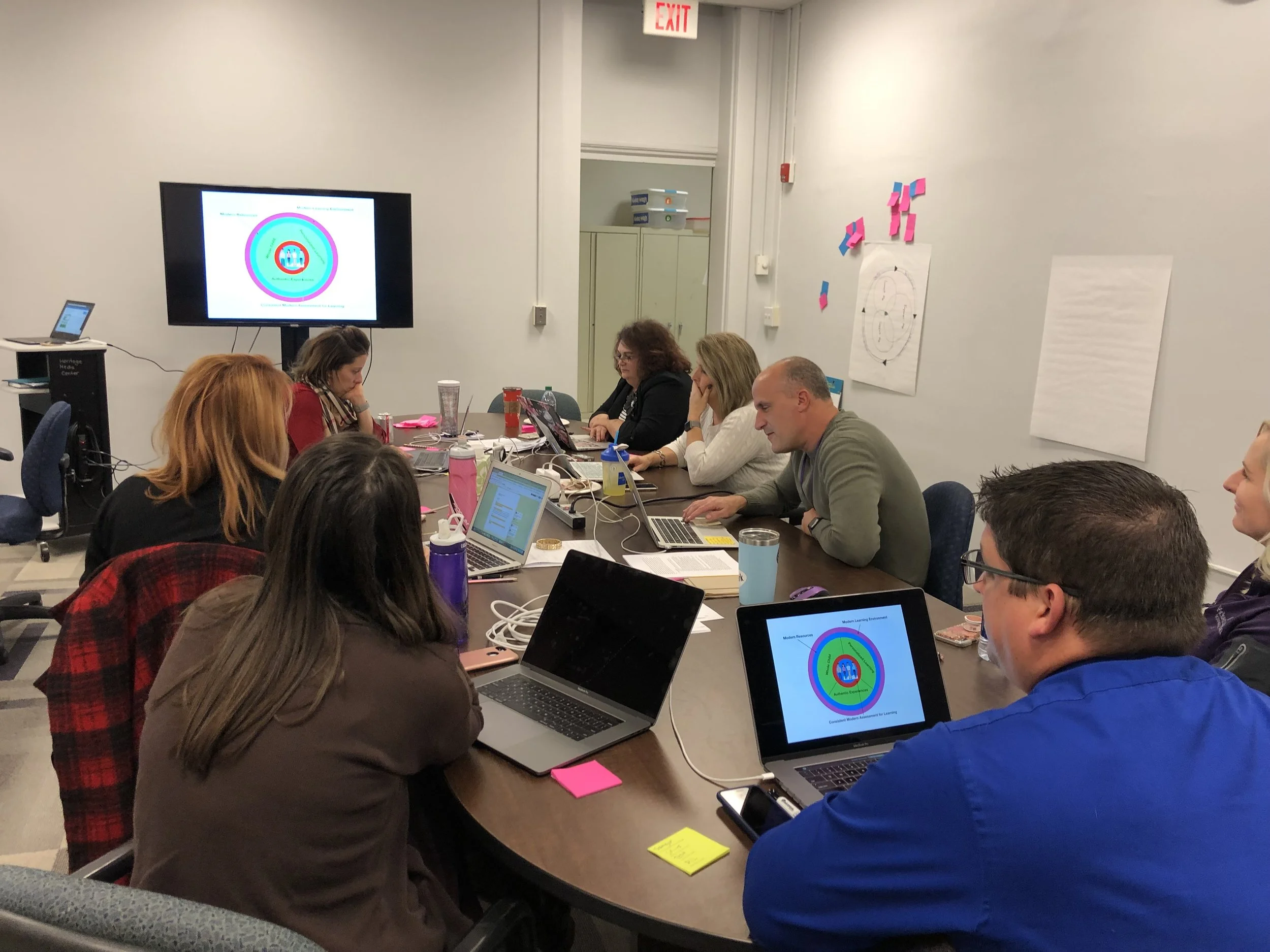 Brian Seymour explains the first of his group’s two instructional model draft graphics to the steering committee.