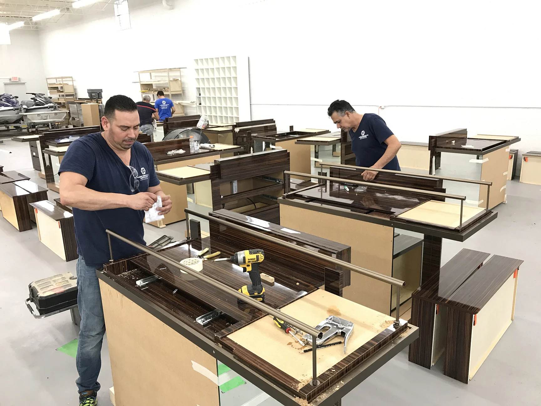 Workers assembling custom retail display fixtures in a manufacturing workshop