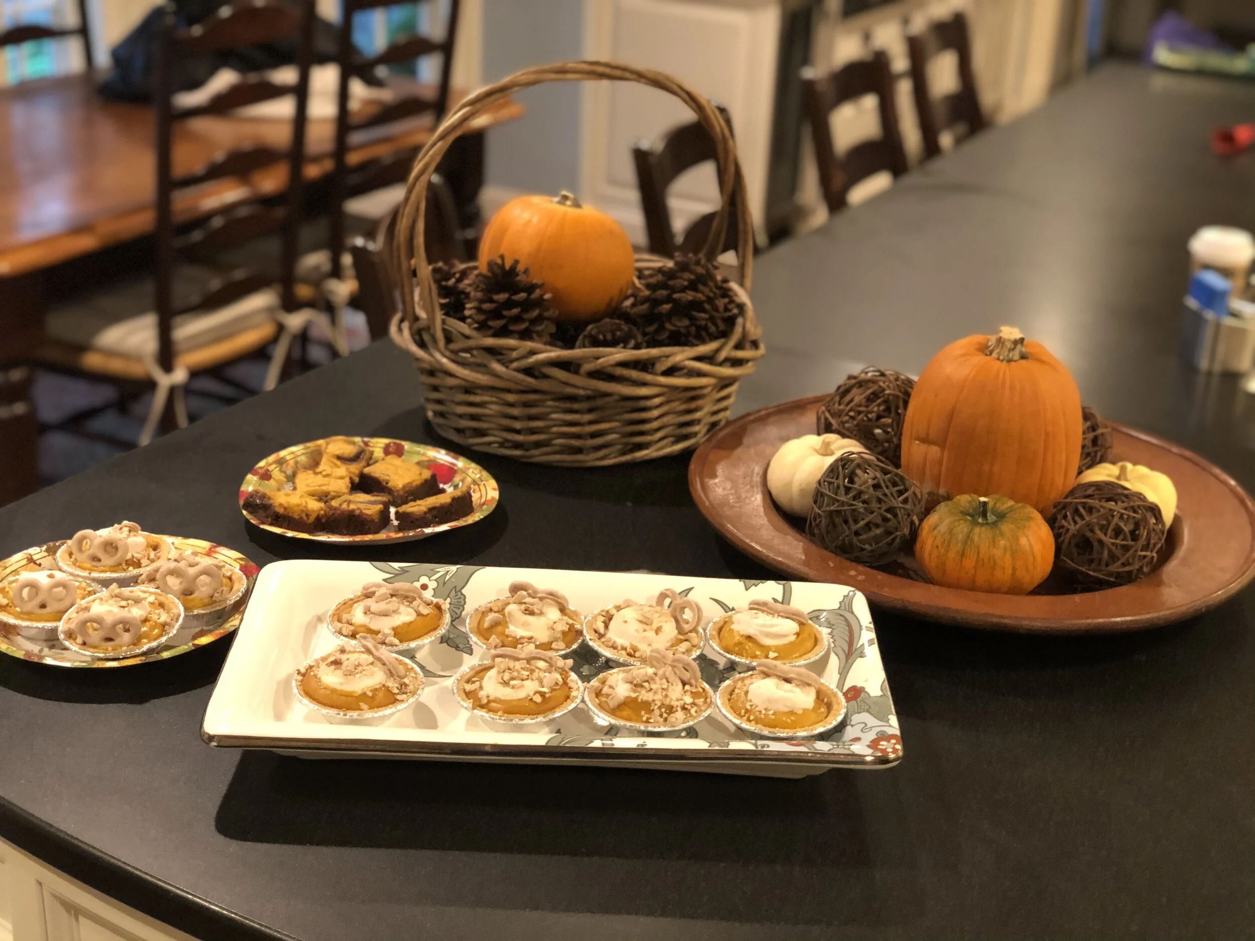 Those are my current centerpieces in the kitchen as well as what remains of a batch of pumpkin cheesecake brownies. I’m not sure chocolate and pumpkin really go together but you can find the recipe here . I subbed 1/2 cup of pumpkin for the egg in the cream cheese topping. Easy Pumpkin Pudding Pies I package instant vanilla pudding 1 15 oz can of pumpkin puree 1 12 oz can evaporated milk 1 tsp pumkin pie spice 2 6 packs of mini graham cracker crusts 1 package pumpkin marshmellows 1 package apple cider yogurt covered pretzels 1. Mix pudding mix and evaporated milk in a medium bowl. Refrigerate 10 minutes. Add pumpkin and spice. 2. Spook evenly into 12 pie crusts. There may be extra. 3. Top with 1 -2 marshmallows and bake for 5 minutes or until marshmallows are soft. Press marshmallows down with fingers to cover entire pie surface. 4. Chop pretzels into small pieces, reserving 12 whole pretzels. Sprinkle pieces on pies and place whole pretzels as desired. 5. Know that you are a domestic goddess! When people nudge each other and look at you as you walk past, they are saying “That’s the one who made those charming pumpkin pies for the bake sale! She’s the best!”