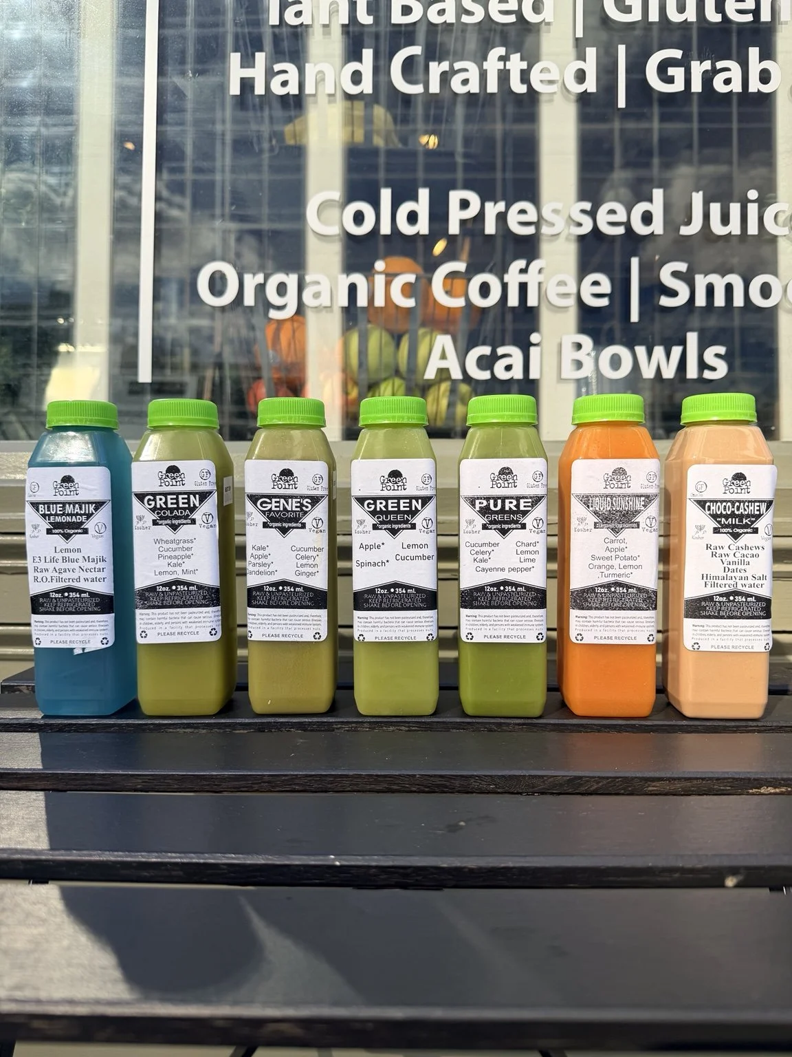 Seven Green Point Juicery cleanse bottles: Blue Majik Lemonade, Green Colada, Gene’s Favorite, Green Queen, Pure Greens, Liquid Sunshine and Chocolate Cashew Milk.