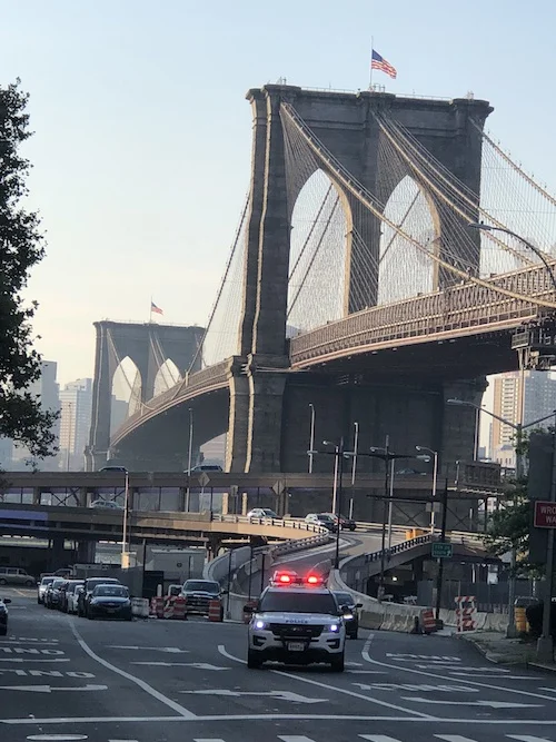 Police car with lights on driving by bridge in NYC.jpg