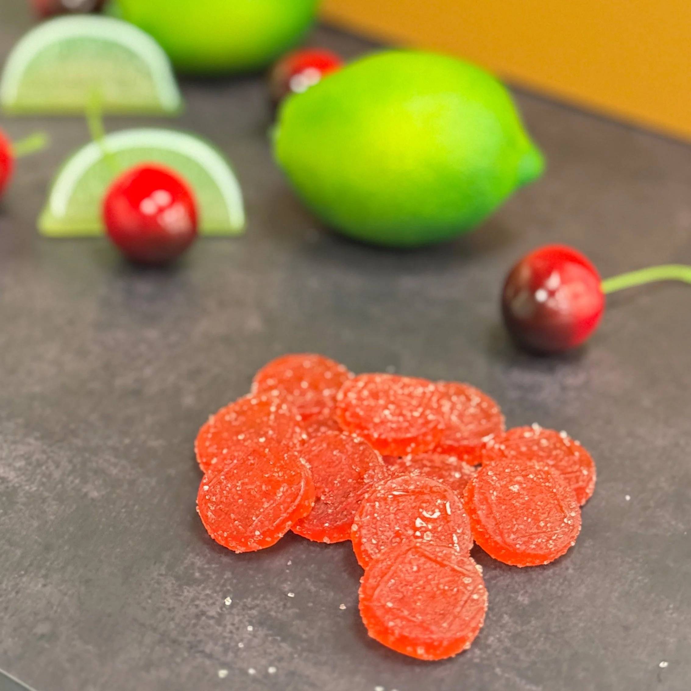 Chillaxing Cherry Limeade gems with limes and cherries in the background
