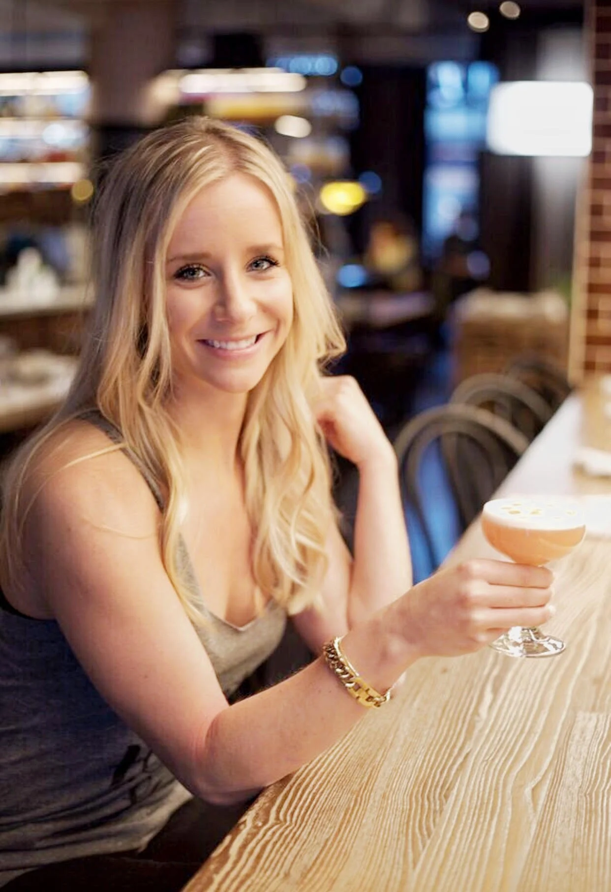 megan holding drink at bar