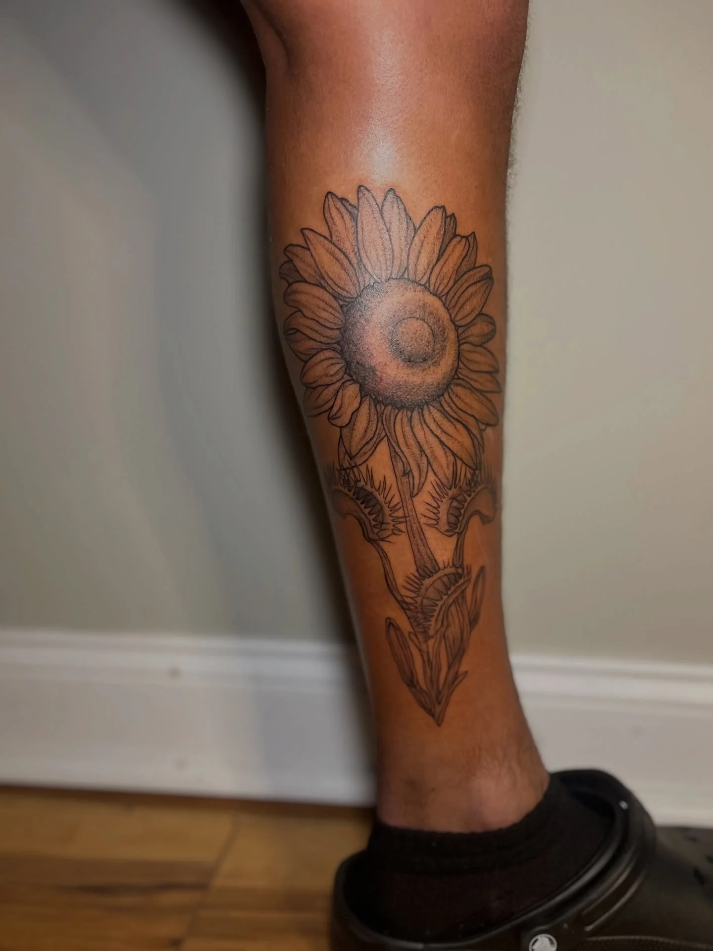 Tattoo of a sunflower on a person's lower leg
