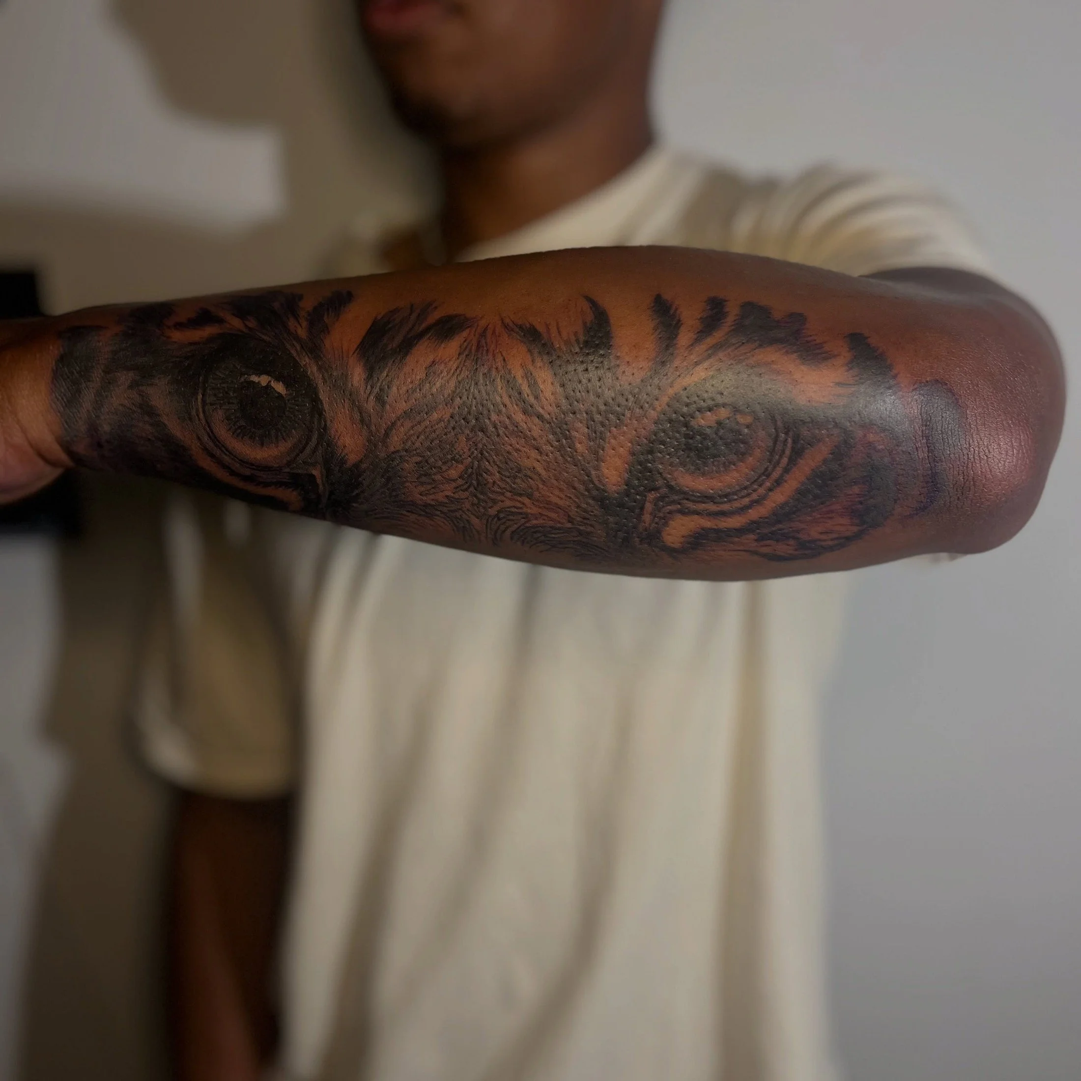Close-up of a person's arm covered with a large, intricate black and gray tattoo design.