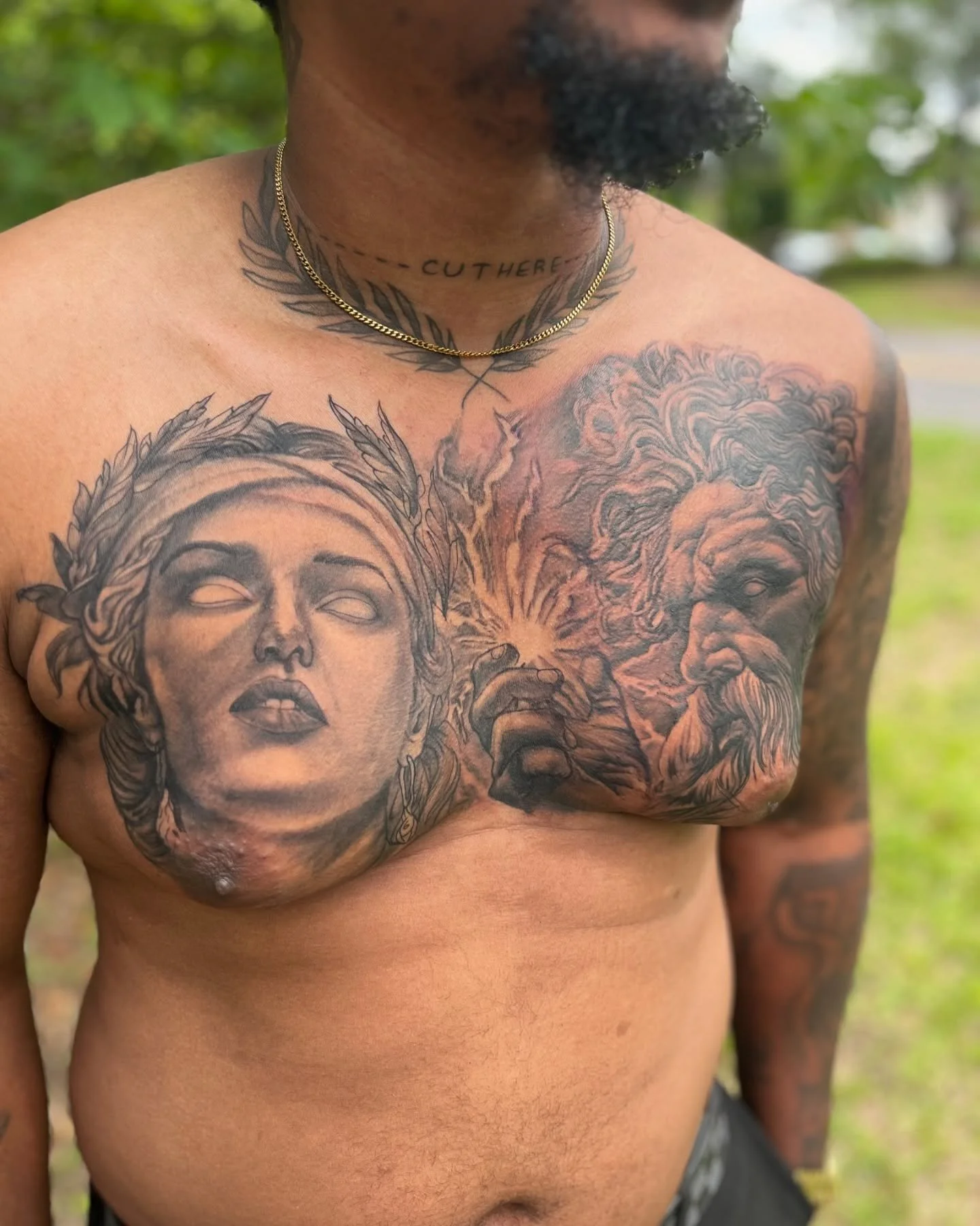 Close-up of a man's chest with detailed black and gray tattoos of a woman's face and a lion, with a gold chain necklace and a tattoo on his neck reading 'CUTHER'.