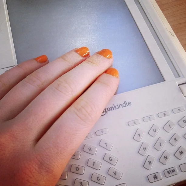 vneckandacardigan :
Orange nails and a ridiculous looking first generation Kindle (Taken with instagram )
It’s not that I don’t appreciate technology. I’m typing on a beautiful white machine that’s not connected to any wires but is connected to the internet and is light enough to rest on my stomach. And I like reading about Alexis has recently eaten, which technology allows me to do. (And I like Alexis, who I even met once.)
It’s just that, how much technology do we need? Because at a certain point (maybe now?) they’re just inventing stuff so we’ll buy more stuff again. For the past 400 years, no one looked at a book, and thought, damn, that shit looks antiquated. But after four years, a first generation Kindle looks “ridiculous."
My often wise dad once said, "We live better than Louis XIV.” Which is true when you think about indoor planning and access to tropical fruit. But it seems like all we’re striving for now is convenience and novelty. But something nice about inconvenient, old things: they’re not part of this absurd cycle of want that technology creates now.