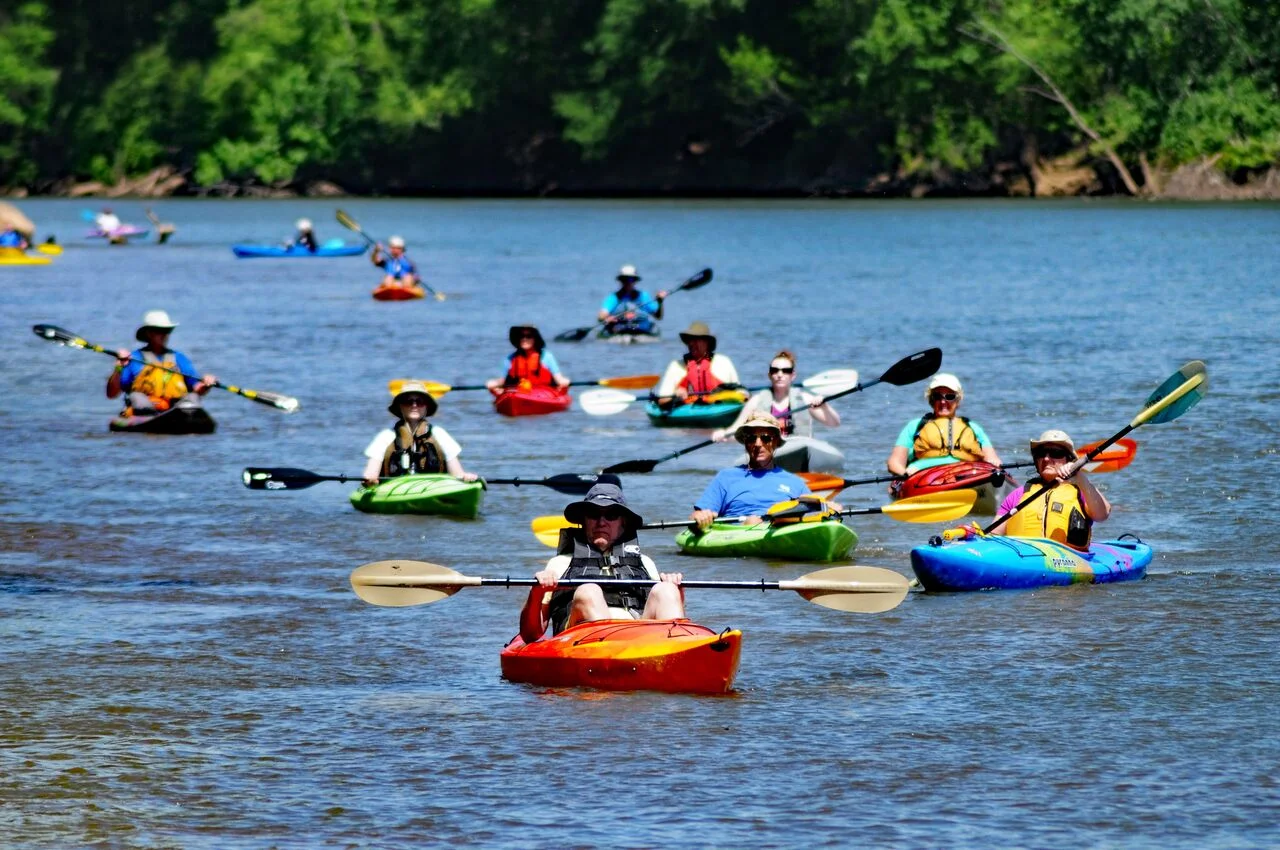 People Kayaking down a river
