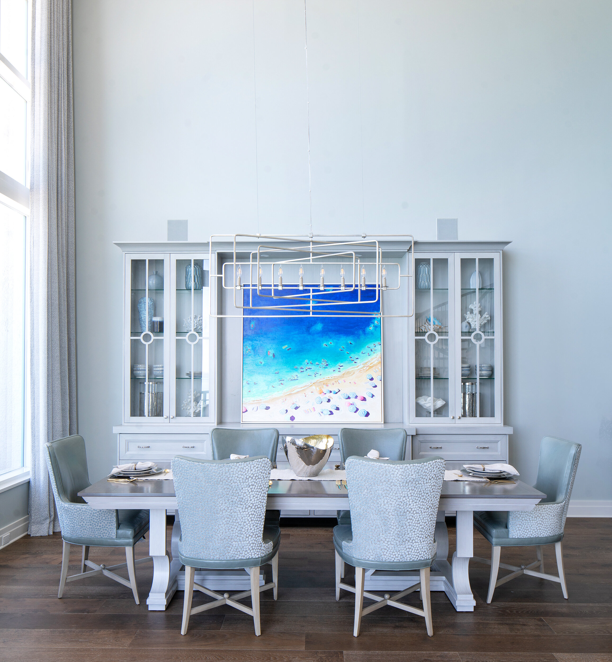 White dining room table with chairs and beach painting