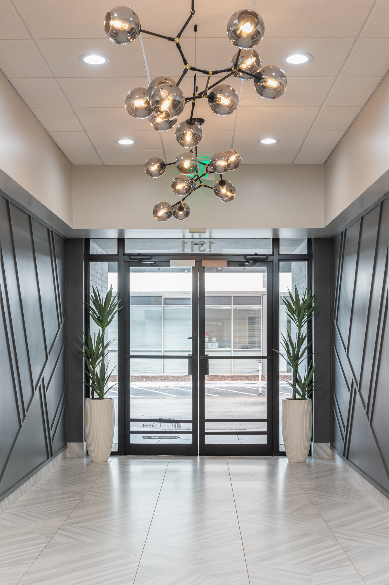 Office lobby big grey wood accent wall and silver ball chandelier