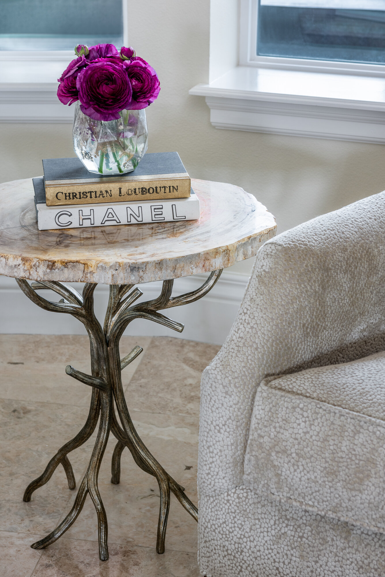 Side table with silver branch details and books and flowers