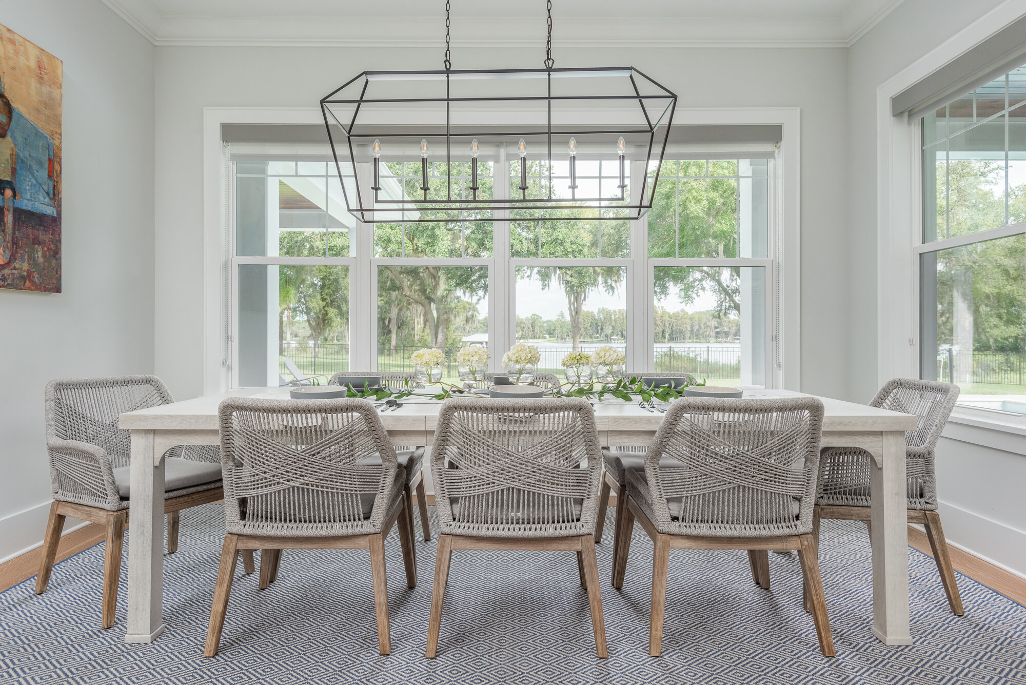 Light brown woven chairs for dining room with black metal chandelier