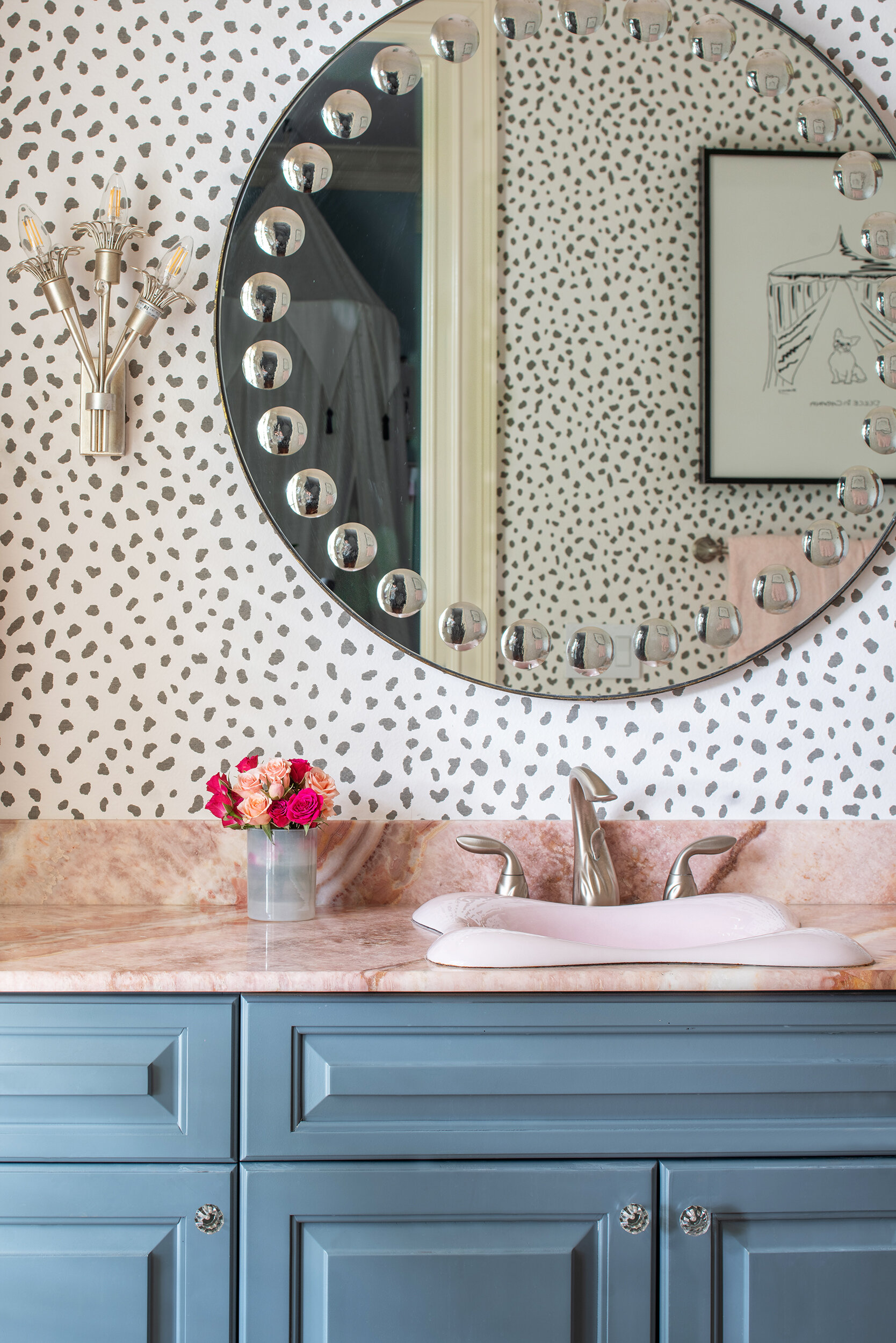 Girly bathroom polka dot wallpaper blue cabinets and pink counter