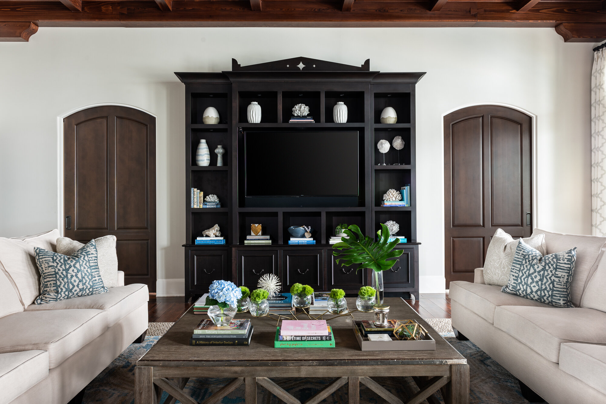 Bright white living room with black wood center console with shelves