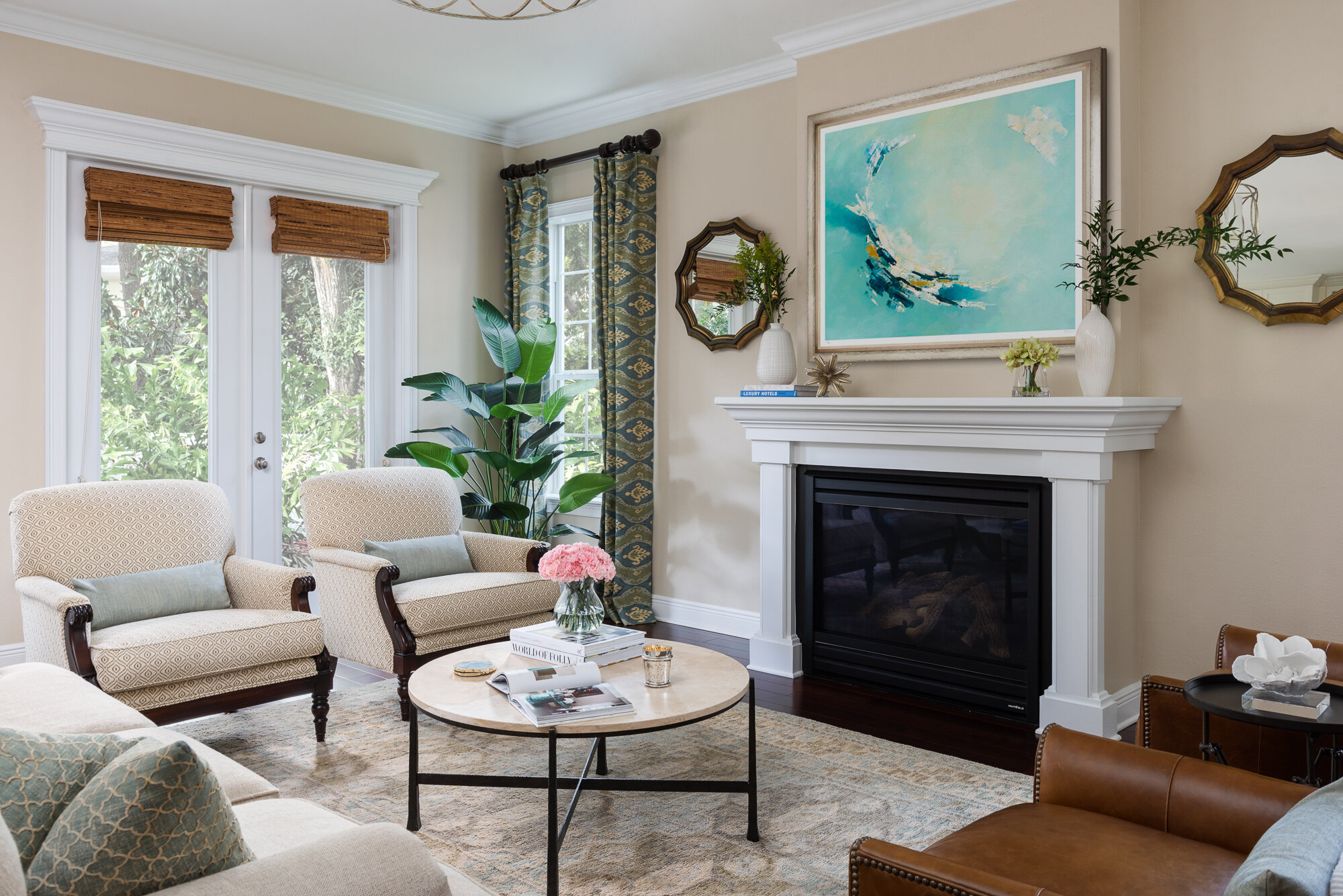 Traditional warm living room with armchairs, fire place, and blue painting