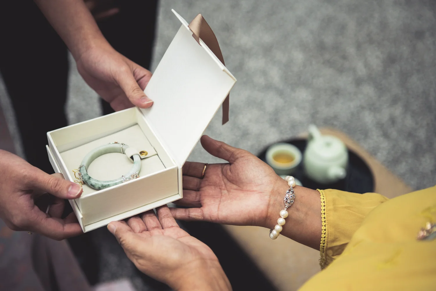 The groom’s mother presents the bride with a gift after the tea has been served.