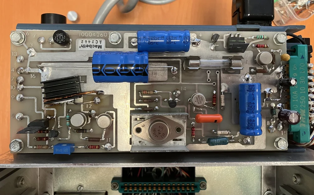 Power supply board, after replacement of capacitors and a few diodes. DIrectly soldered below is the mains transformer and adjacent is a radiator, containing the main pass transistors