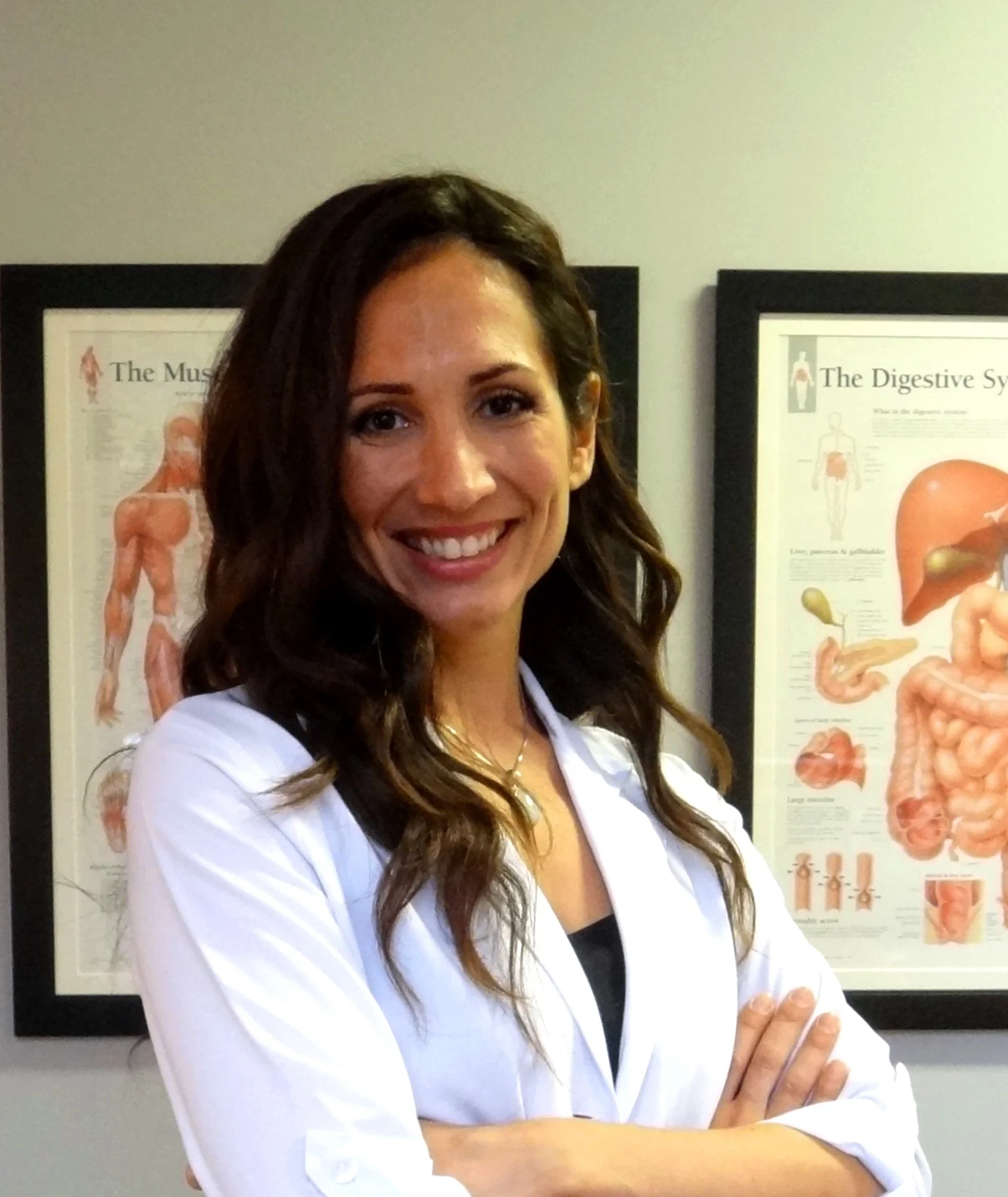 Portrait professionnel de Zeina Raya, massothérapeute et naturopathe à Ville-Émard, Montréal, souriante et portant un sarrau blanc.