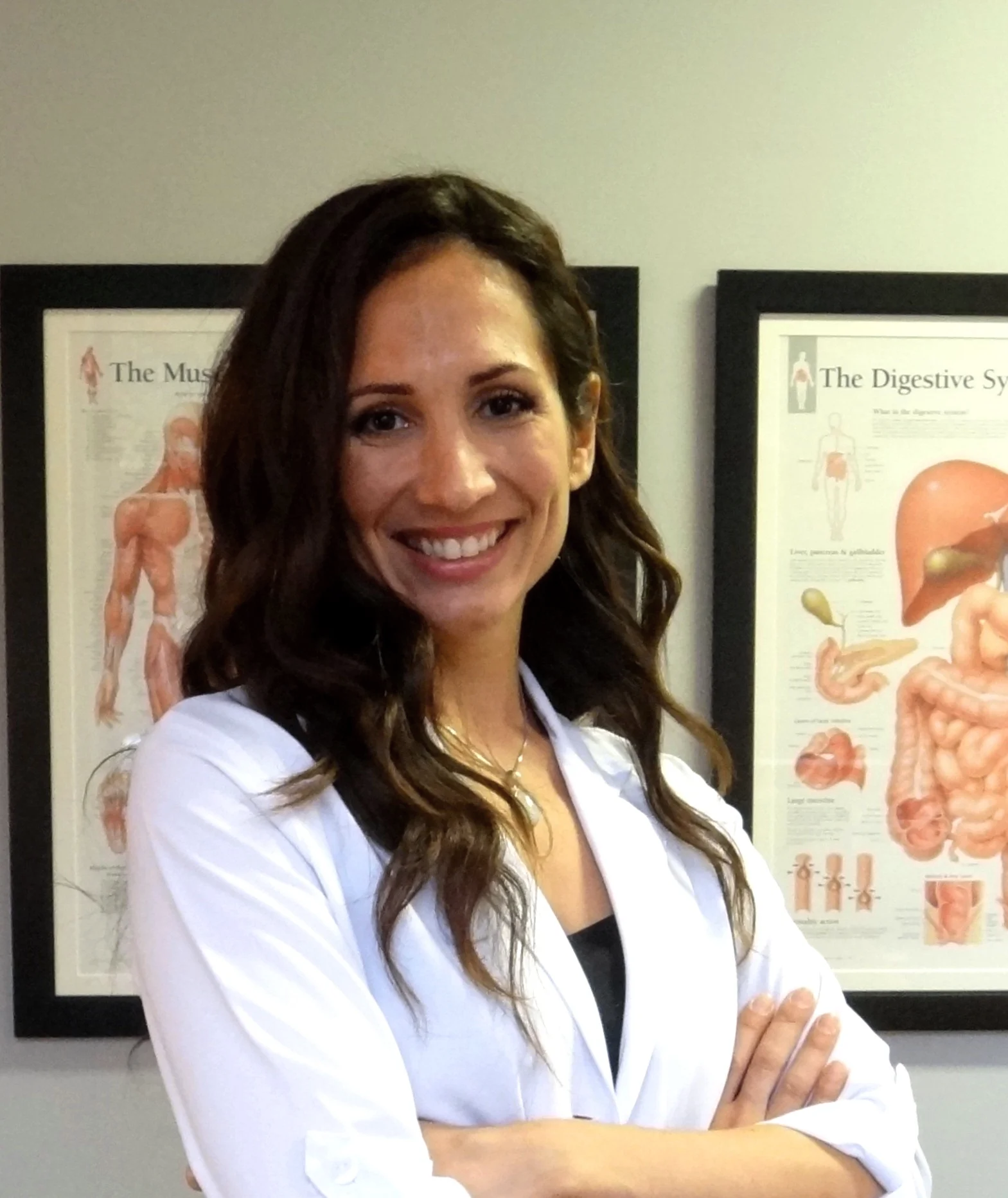 Portrait of Zeina Raya, naturopath and massage therapist in Montreal, wearing a white professional coat in her clinic.