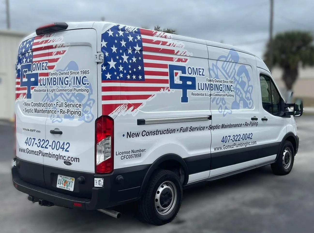 A white company van with patriotic American flag graphics and blue lettering advertising Gomez Plumbing Inc., a licensed plumbing business with services like new construction, septic maintenance, and re-piping. The van has a Florida license plate and