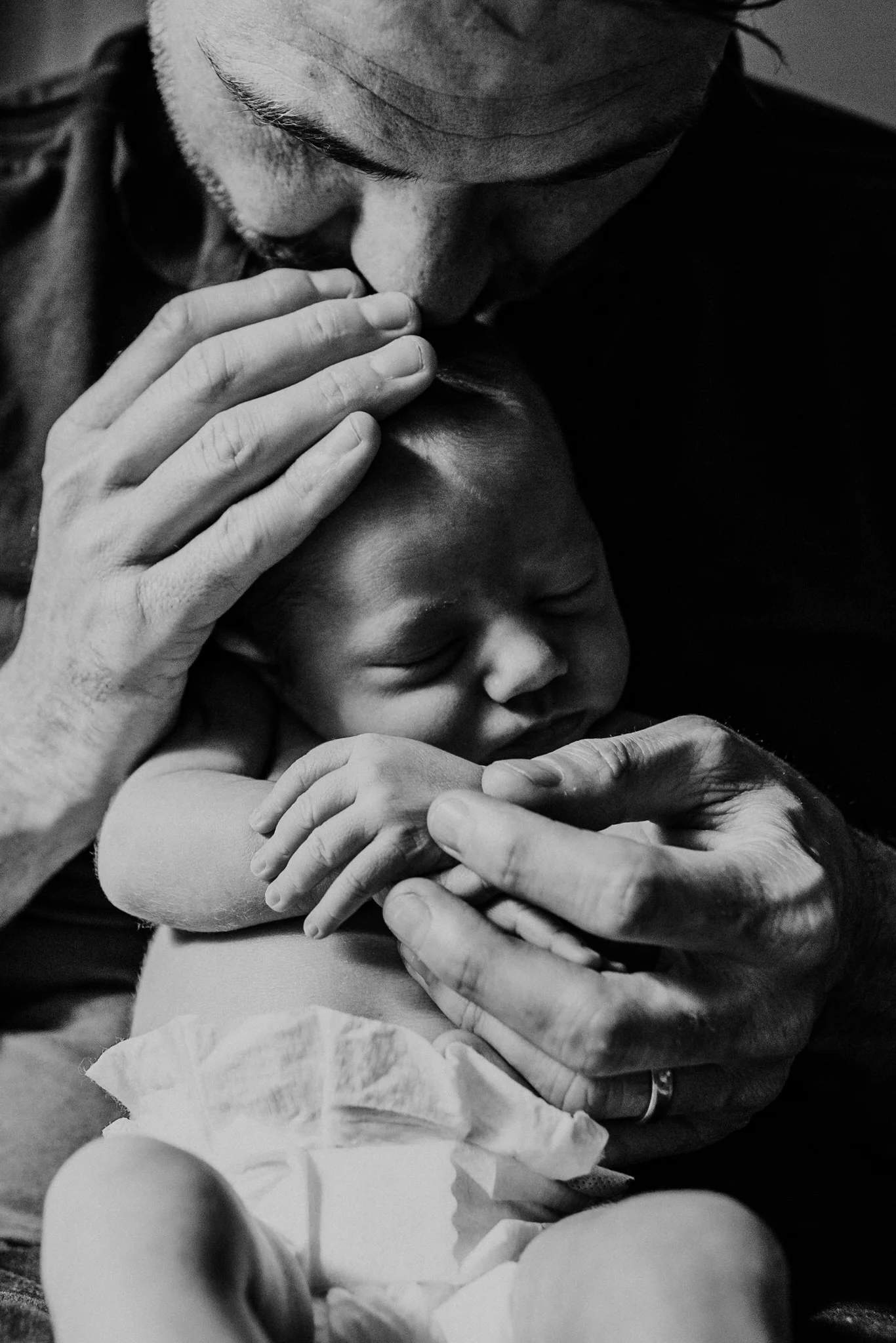Close up image of Dad holding newborn baby