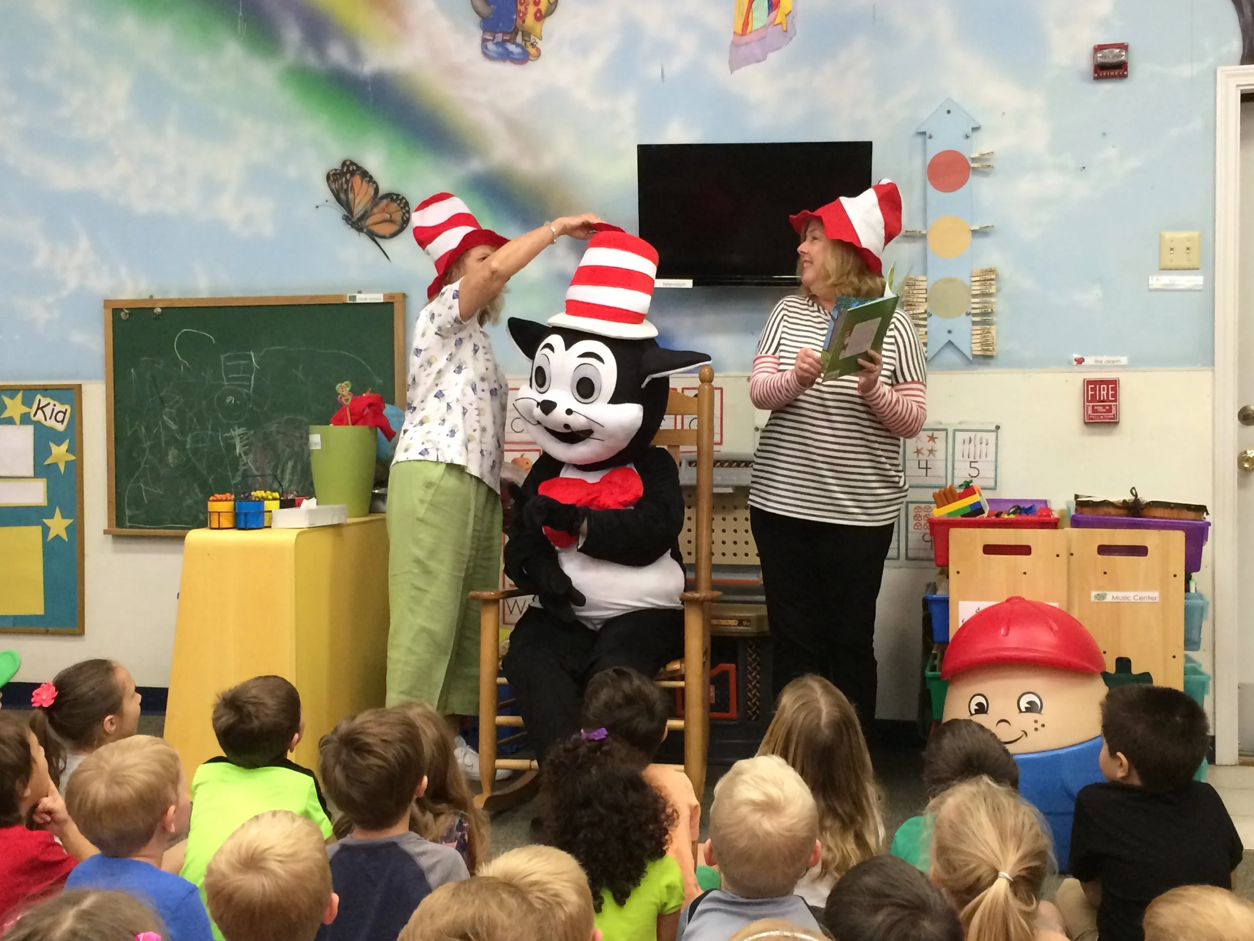 ELC volunteers Kathy Stawawa and Teresa Widman reading the book “Ten Apples Up on Top” by Dr. Seuss with special guest The Cat in the Hat during a Dr. Seuss program at Kids First Learning Center in Middleburg. 