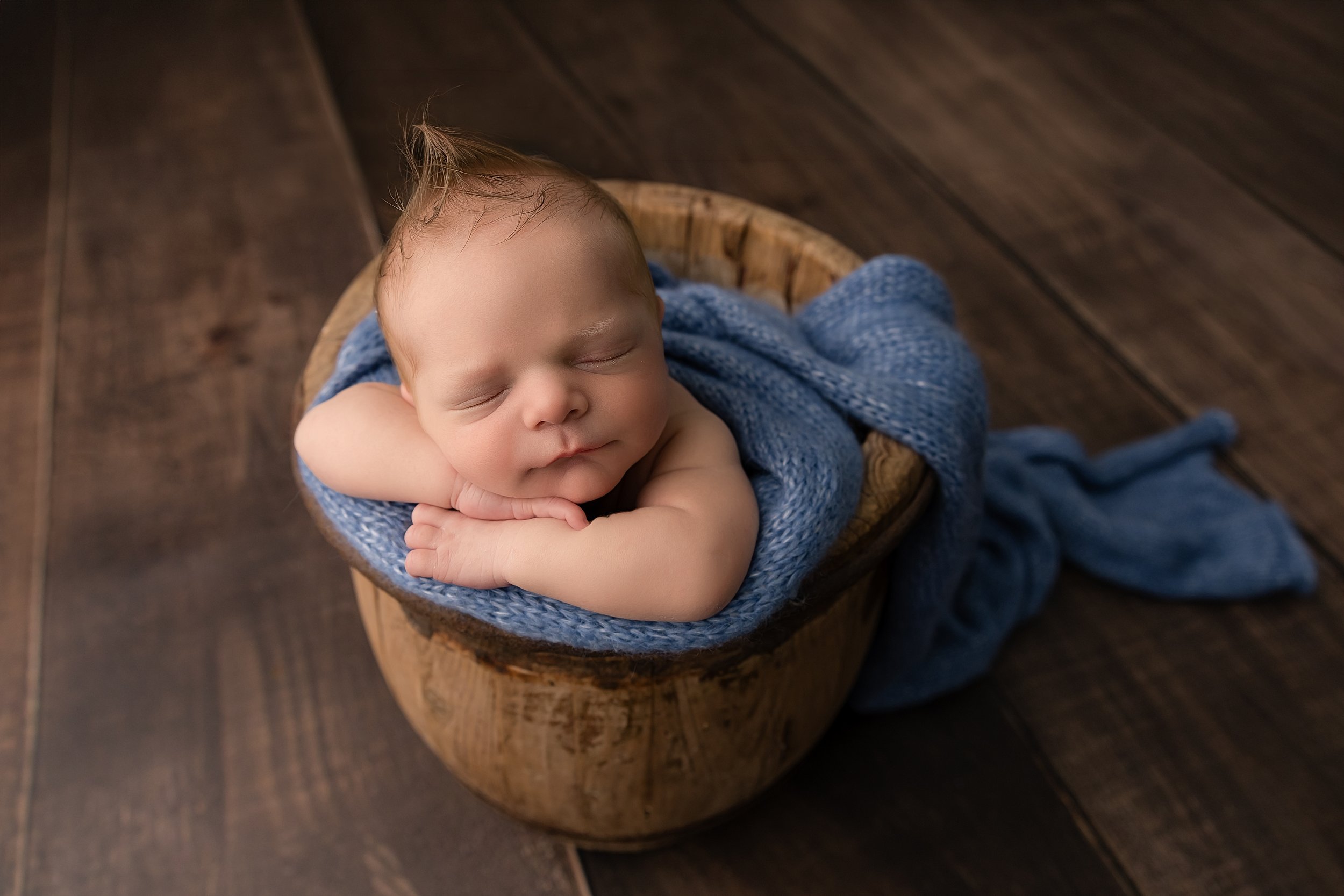 newborn baby posed in a bucket at his newborn photography session in Evans ga by Stacey Brenner Photography