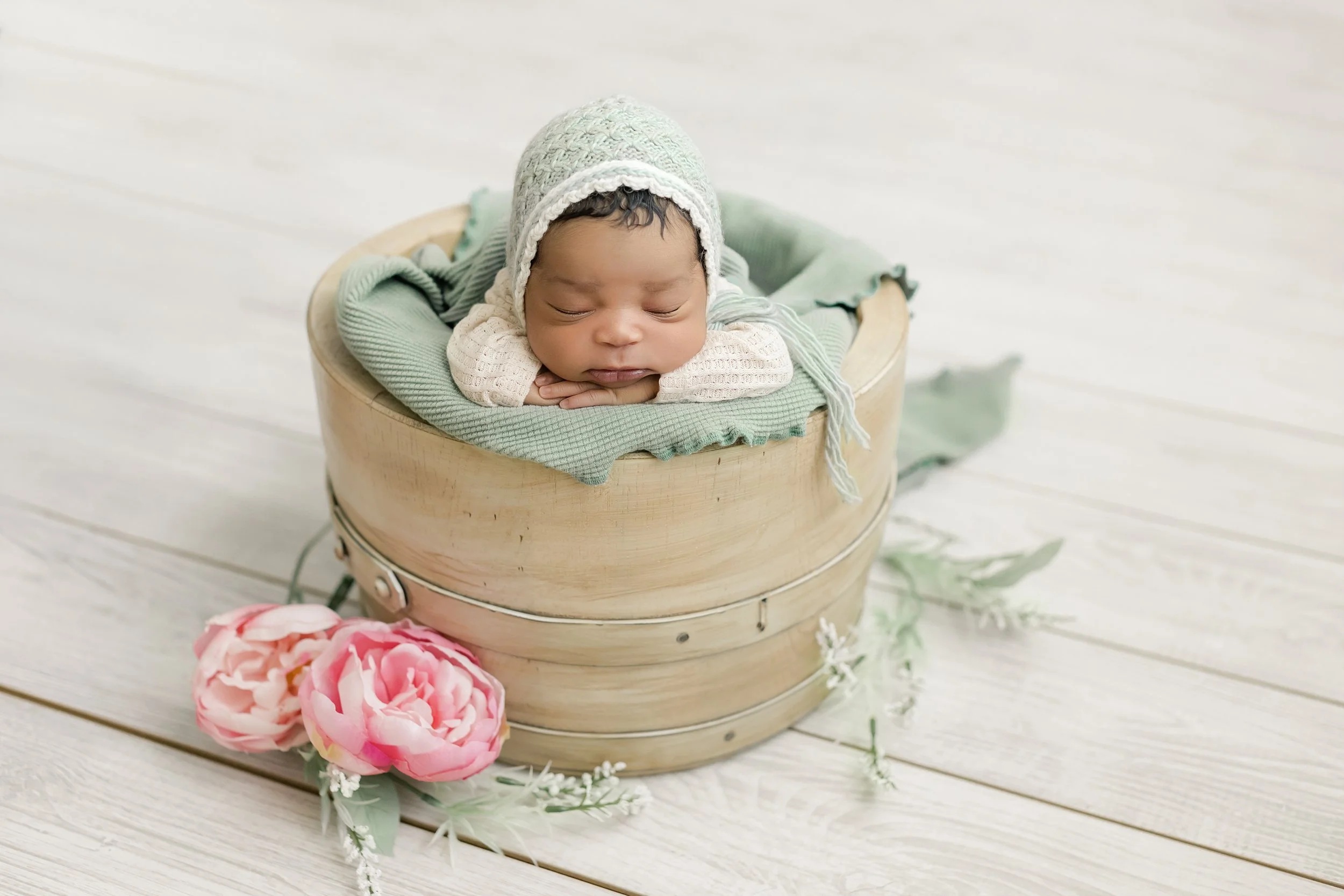 baby girl posing in a round bowl at her newborn photography session in Augusta, ga