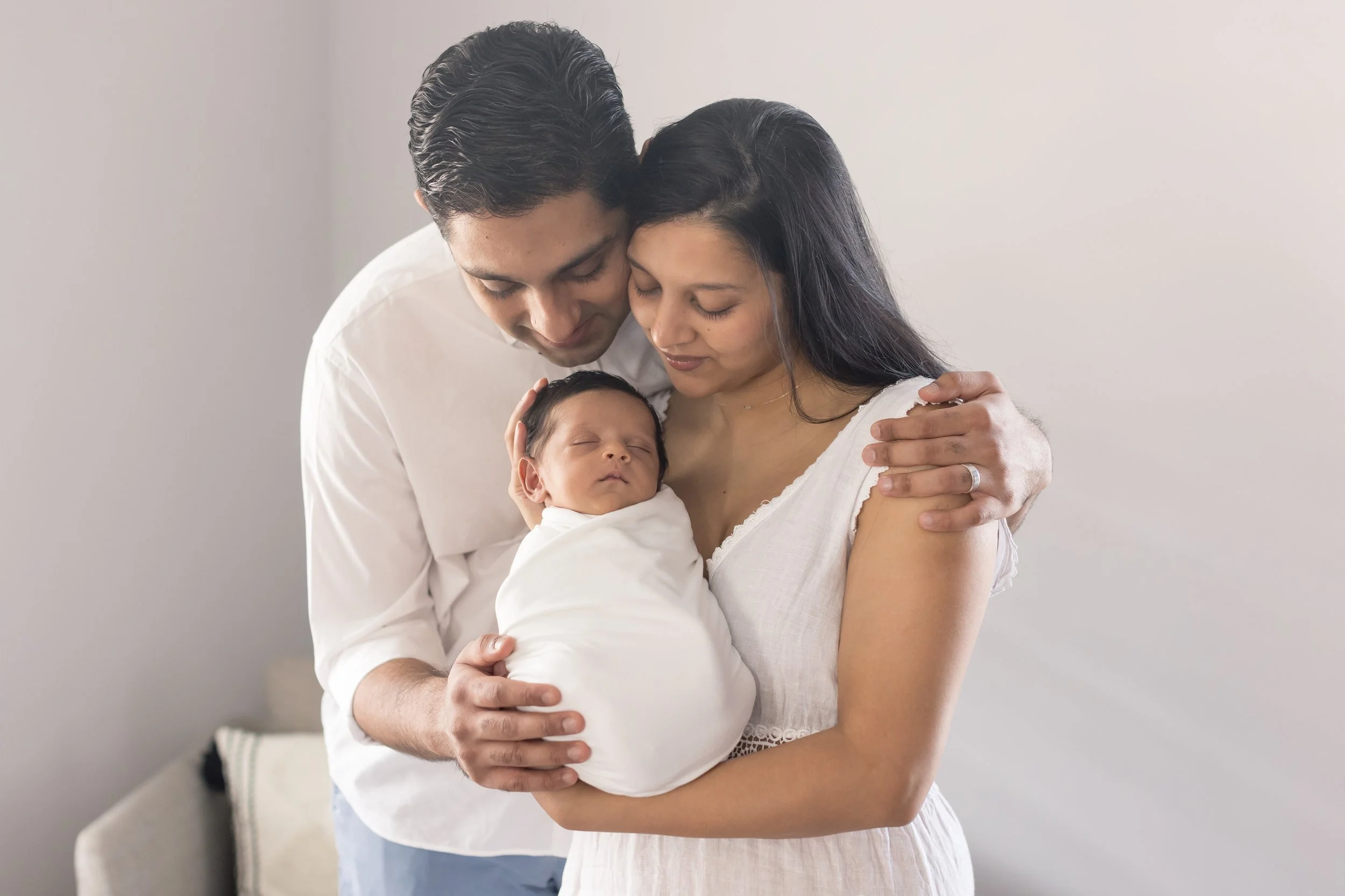 mom and dad holding newborn baby boy at their inhome newborn photography session in Evans, ga