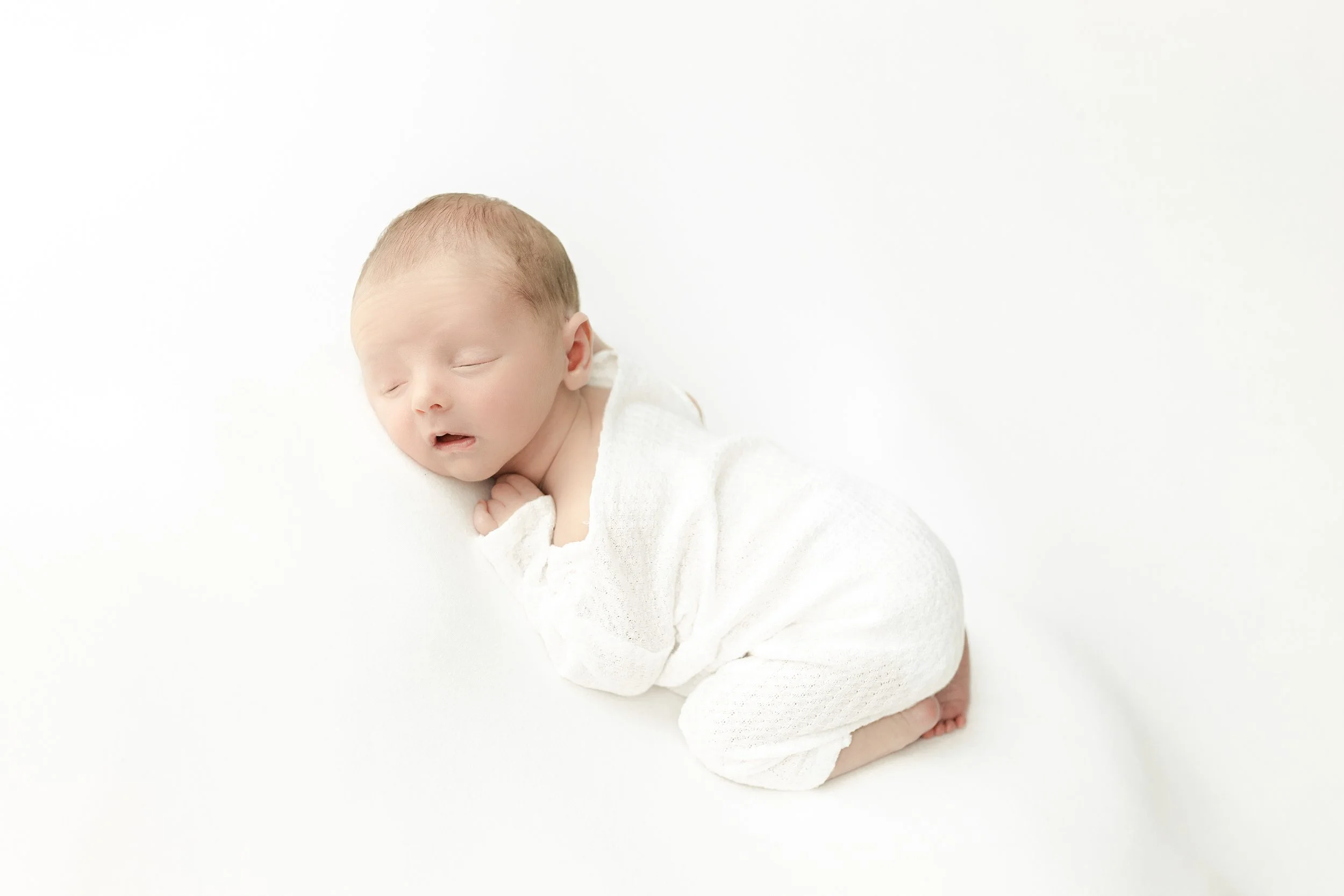 newborn baby laying down for his portraits at his newborn photography session in Augusta ga