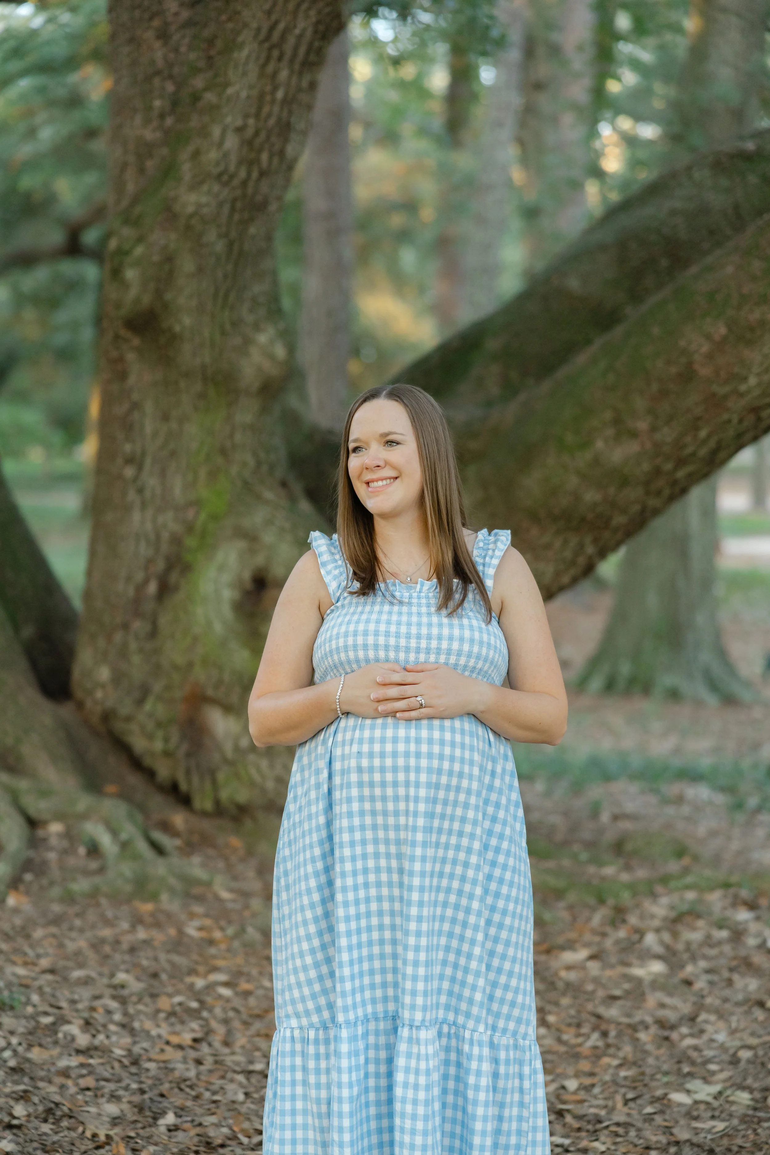 Pregnant woman posing in a flowing dress at Hopeland Gardens in Aiken, SC