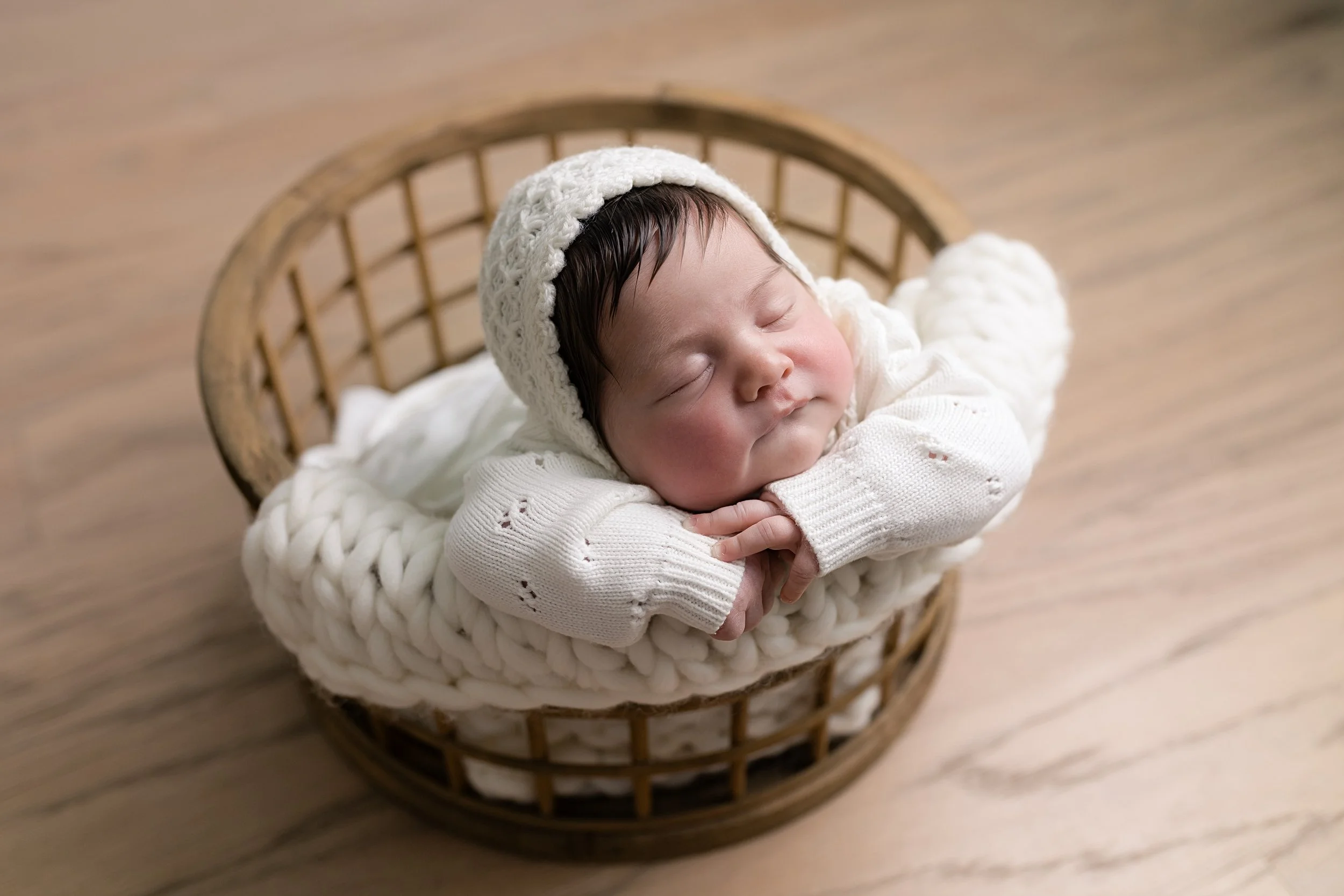 newborn baby girl posed in a basket at her newborn photography session in Augusta, ga