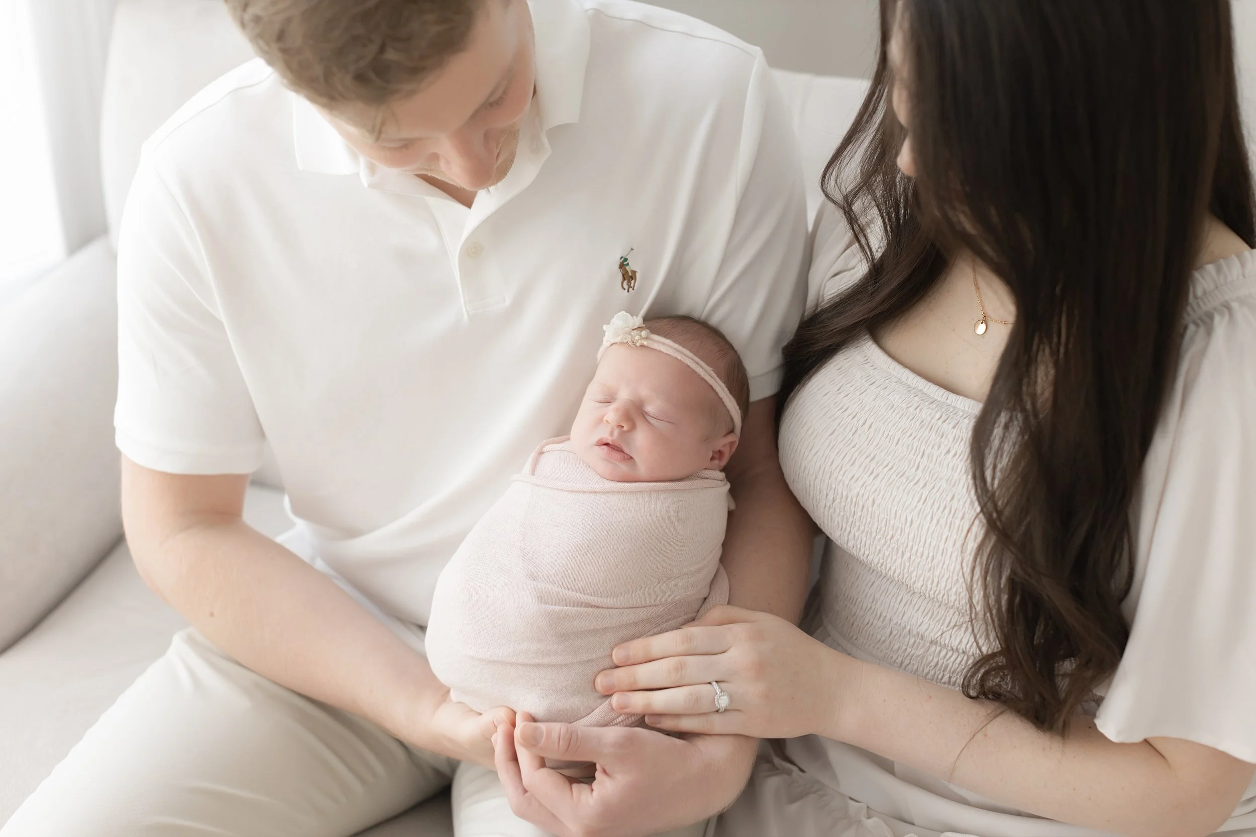 newborn baby girl wrapped and being held by mom and dad at her studio newborn photography session in Evans ga