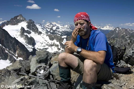 Mountaineer Steve Smith applies sunscreen on a bright day.Ragged Ridge, North Cascades Washington.