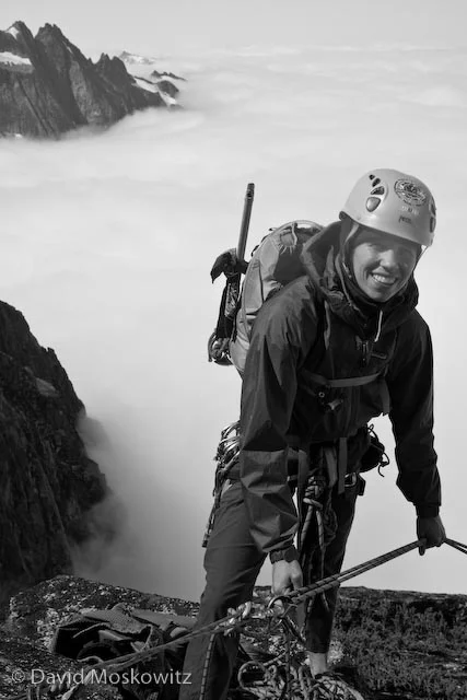 Samantha at a belay ledge soon after getting on the arete, just above the layer of clouds which filled the Marble Creek drainage.
