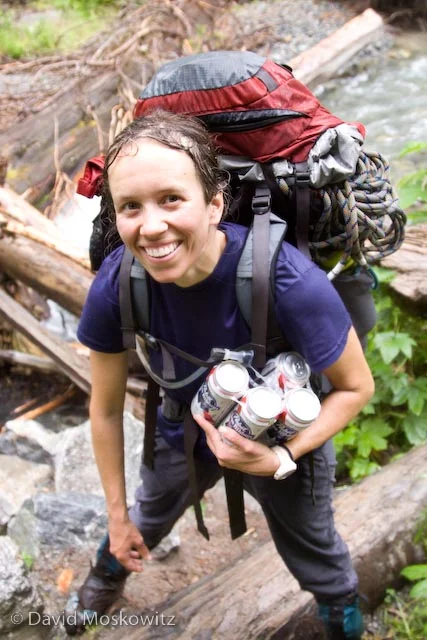 Soaking wet from a long descent in pouring rain, Samantha completes a successful trip with the safe retrieval of several cans of Pabst Blue Ribbon beer from the Cascade River.
