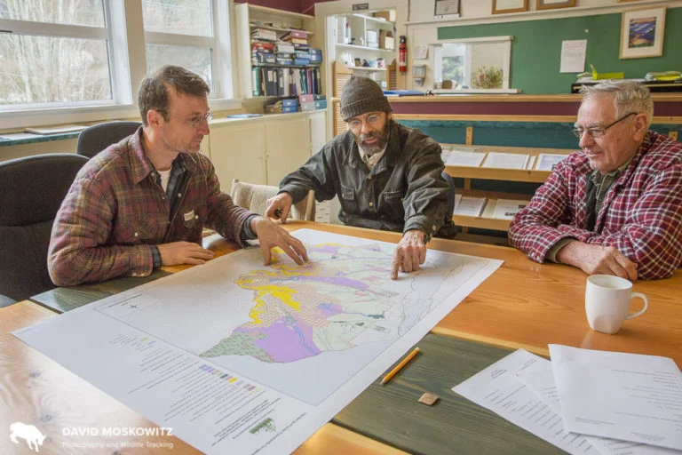 Erik Leslie (left), the forester for the Harrop-Proctor Community Forest, and two board members look over a map of the region they are responsible for managing.