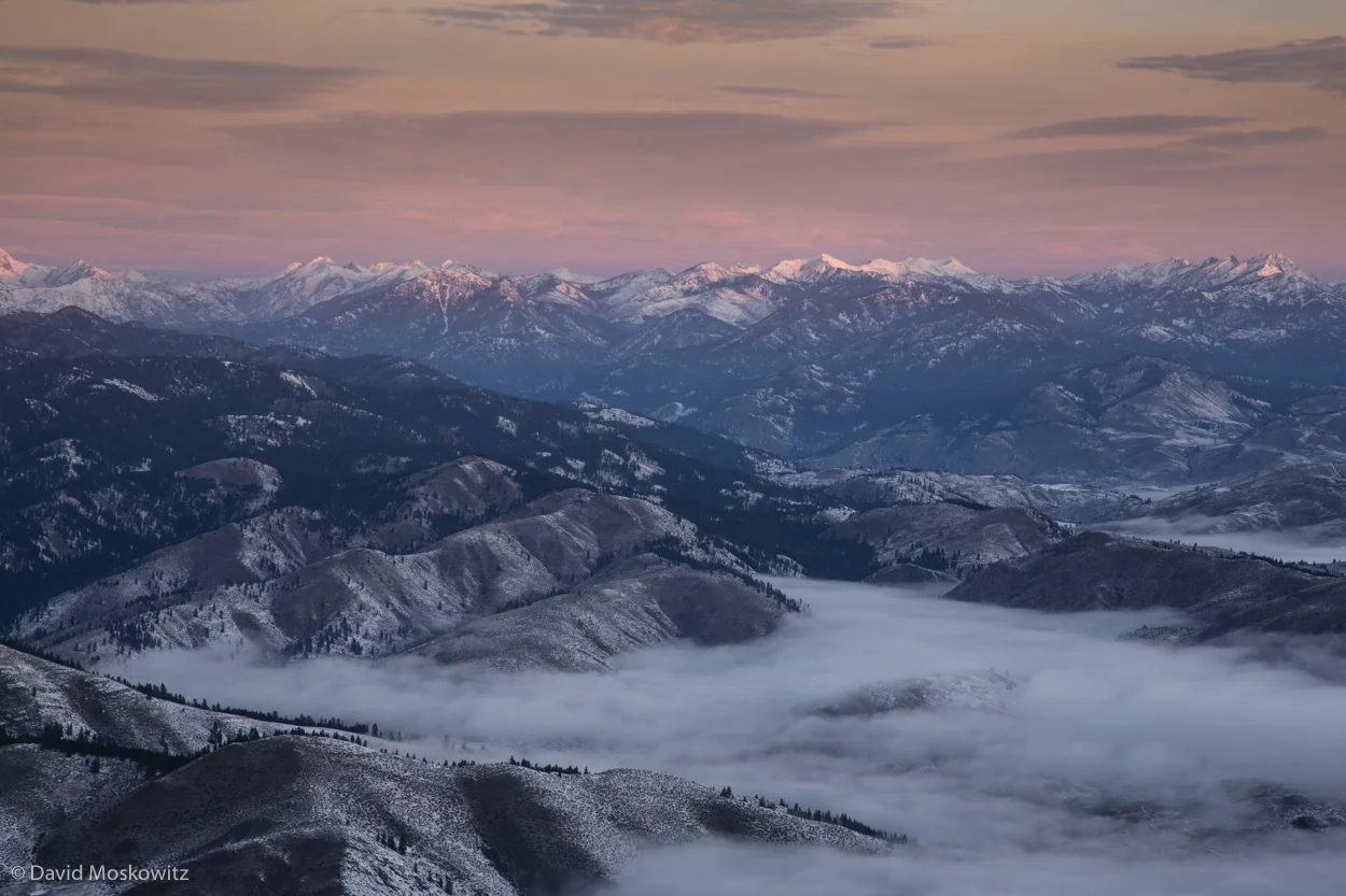 Low clouds cover the Methow Valley as the first light of the day hits the high peaks of the Pasayten Wilderness on the eastern edge of the North Cascades.