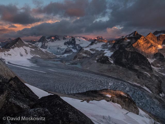 Sunrise over peaks to the North of the Bugaboo Range and the massive tongue of the Vowell glacier below them. As seen from the ridge between Bugaboo Spire and Crescent Spire.