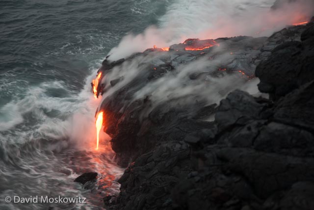 Lava from the Kilauea Volcano on the big isalnd of Hawaii pours over cliffs into the Pacific Ocean.