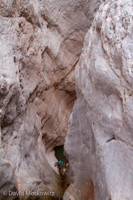  Descending a deep slot in a limestone layer towards a pool of water in Cove Canyon, a tributary of the Colorado River in the Grand Canyon, Arizona. 