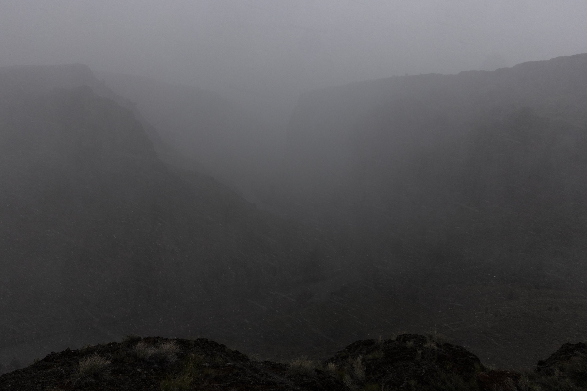 Spring snow squall obscures the Owyhee River flowing through a deep canyon in southeastern Oregon.