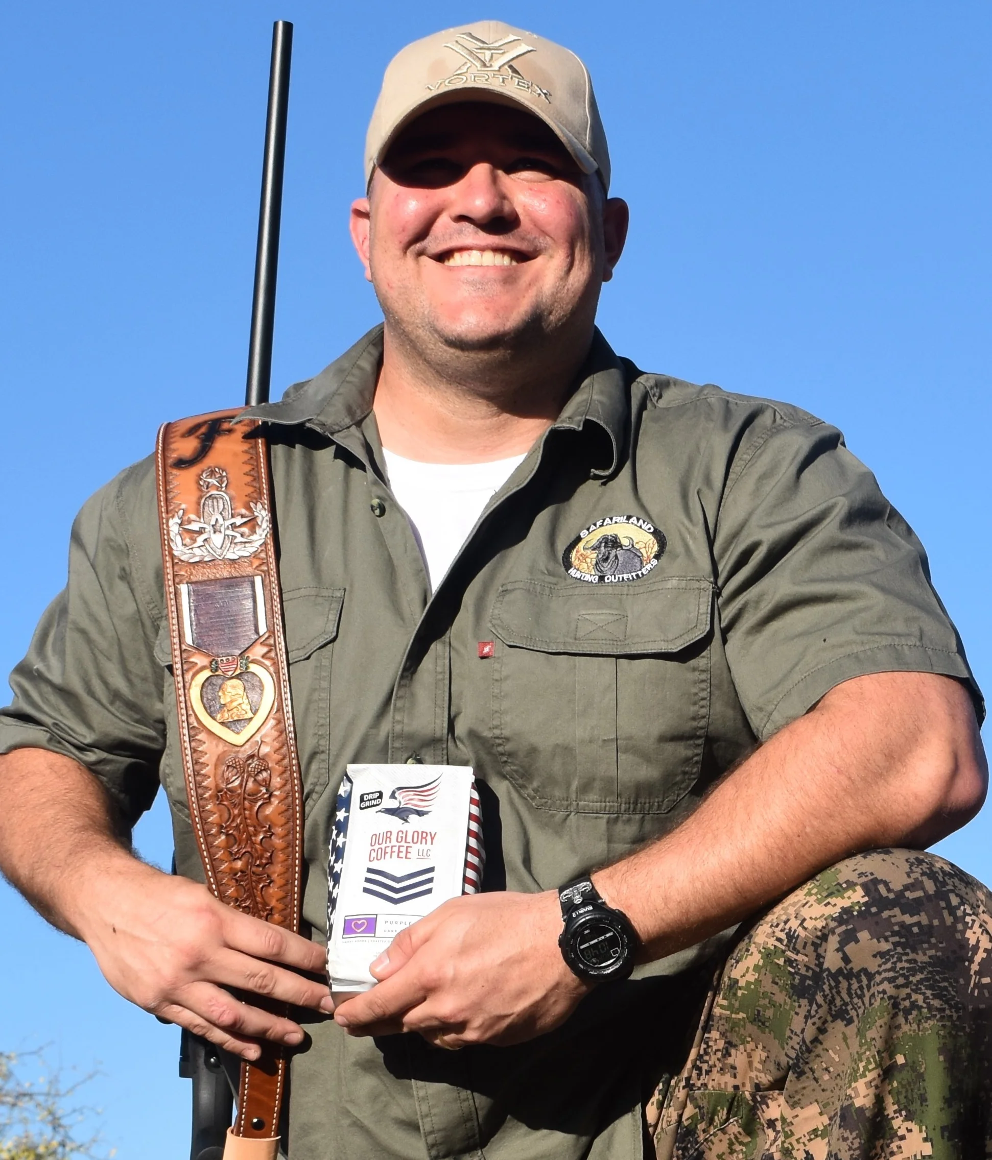 Daniel Fye proudly holding his rifle and a bag of Our Glory Purple Heart coffee.