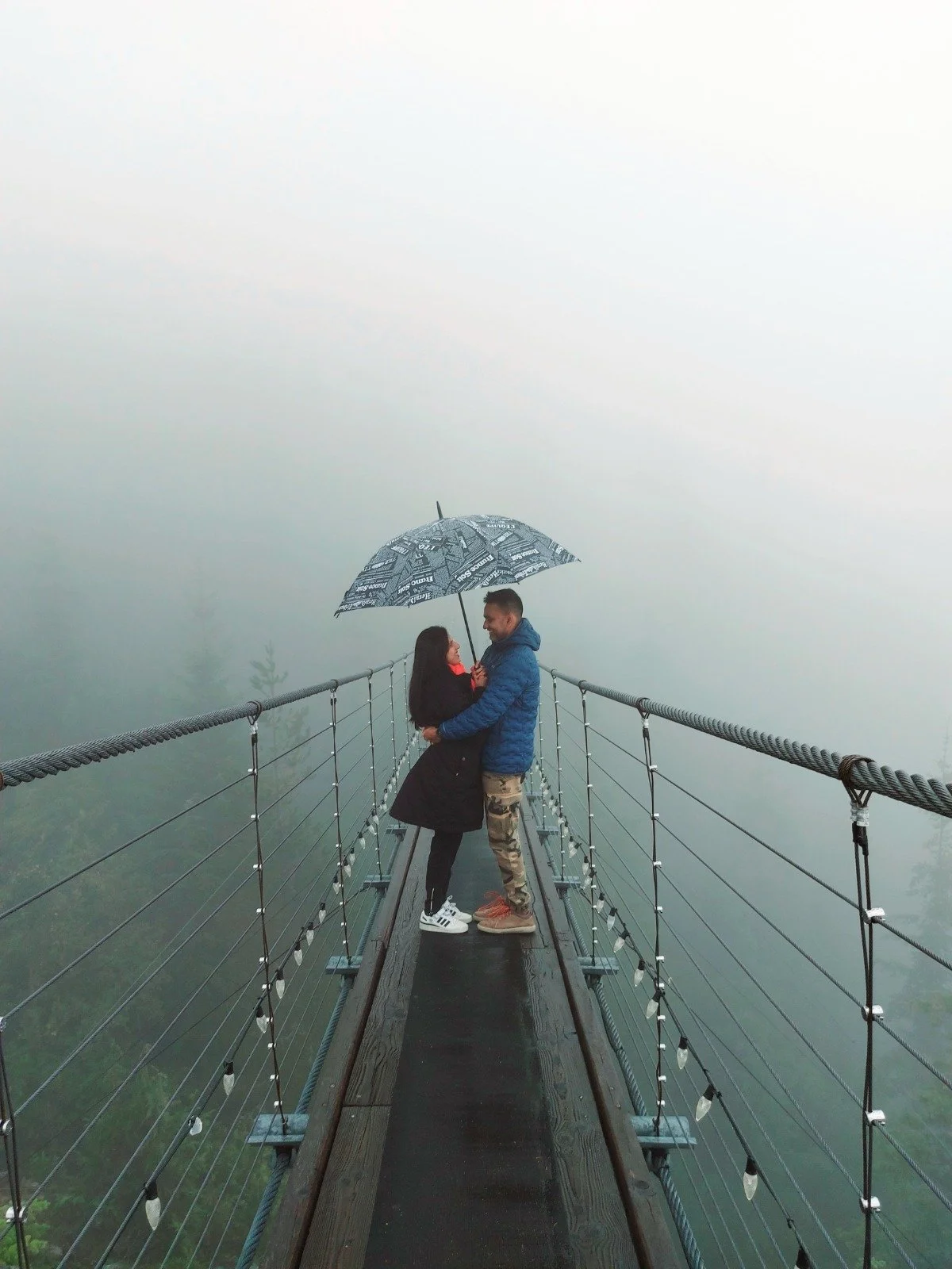 Couples under an umbrella, on a bridge